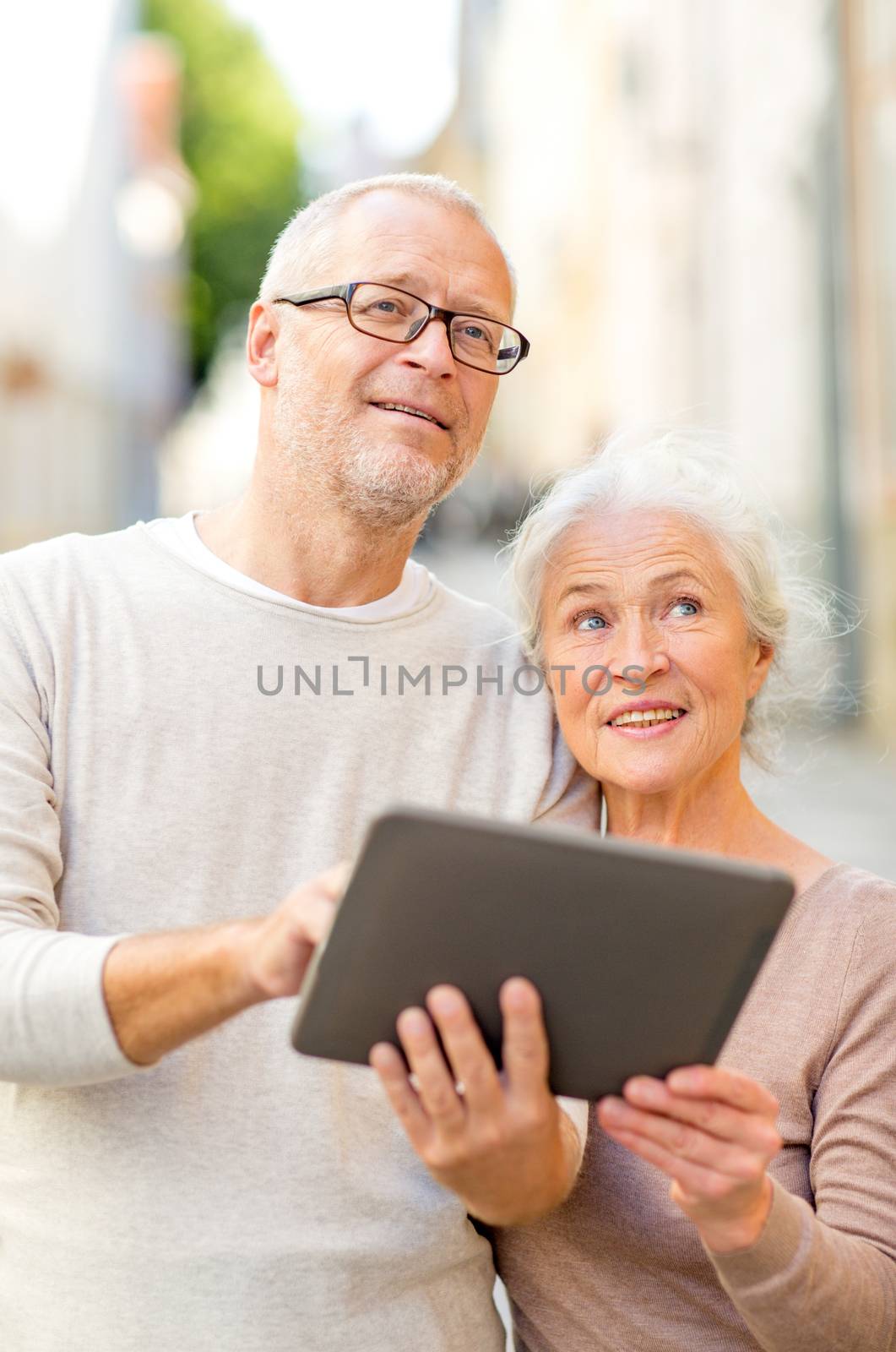 age, tourism, travel, technology and people concept - senior couple with tablet pc computer on street