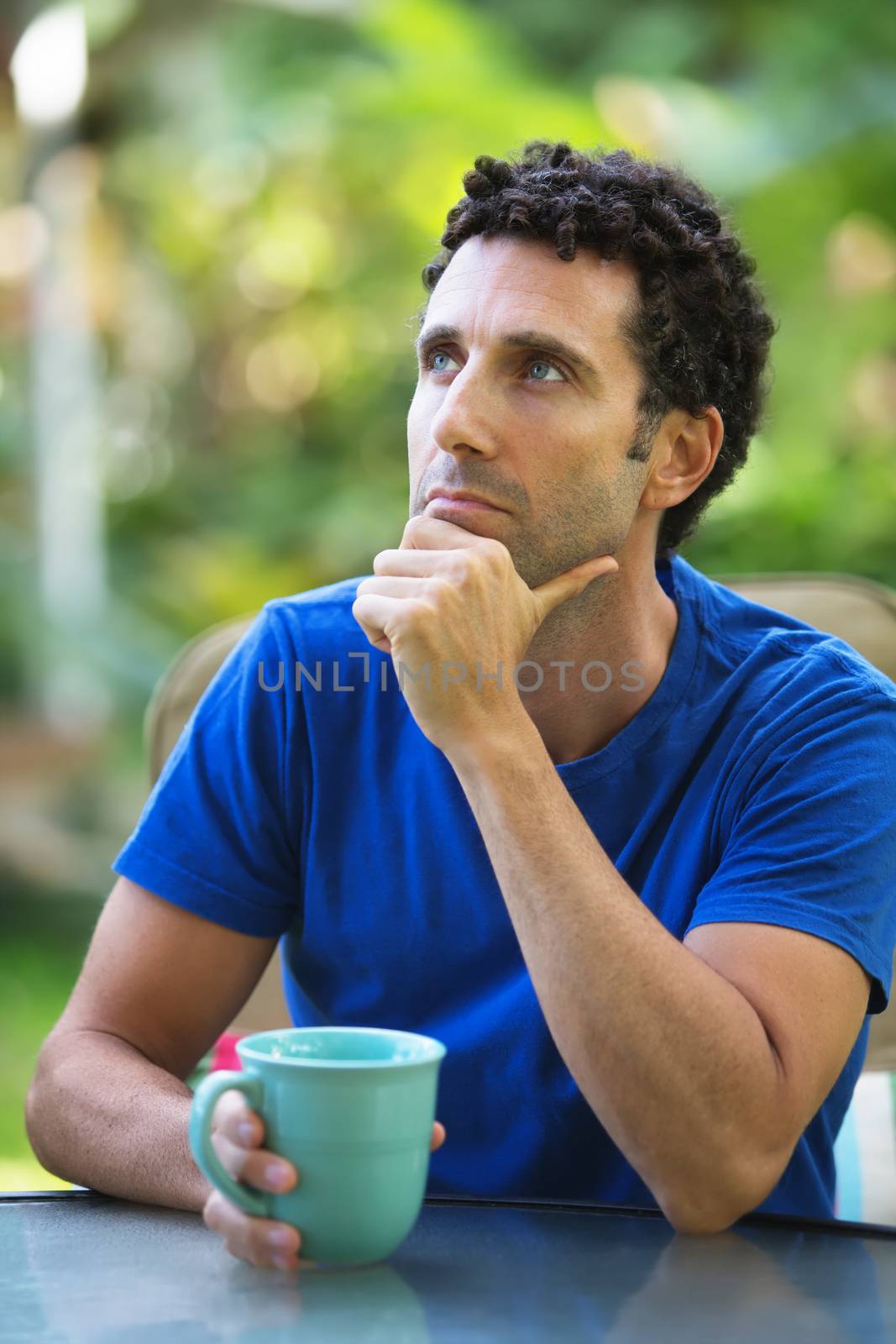 Pensive Caucasian adult sitting outdoors in Maui