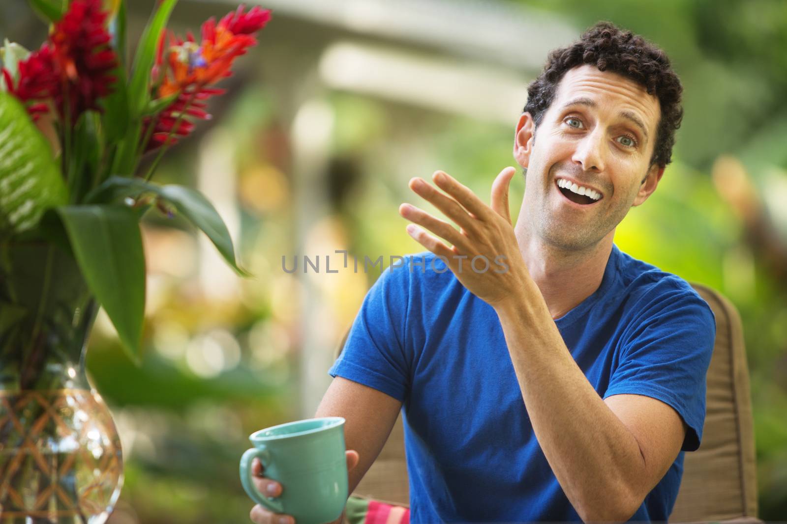 Single Caucasian adult gesturing with hand and laughing