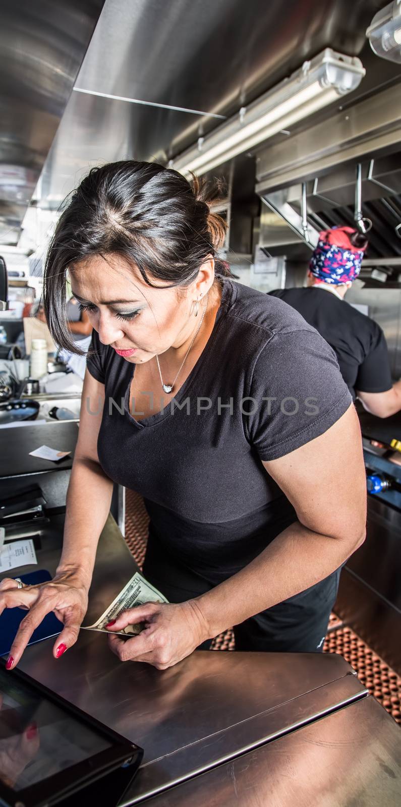 Female cashier with money on busy food truck