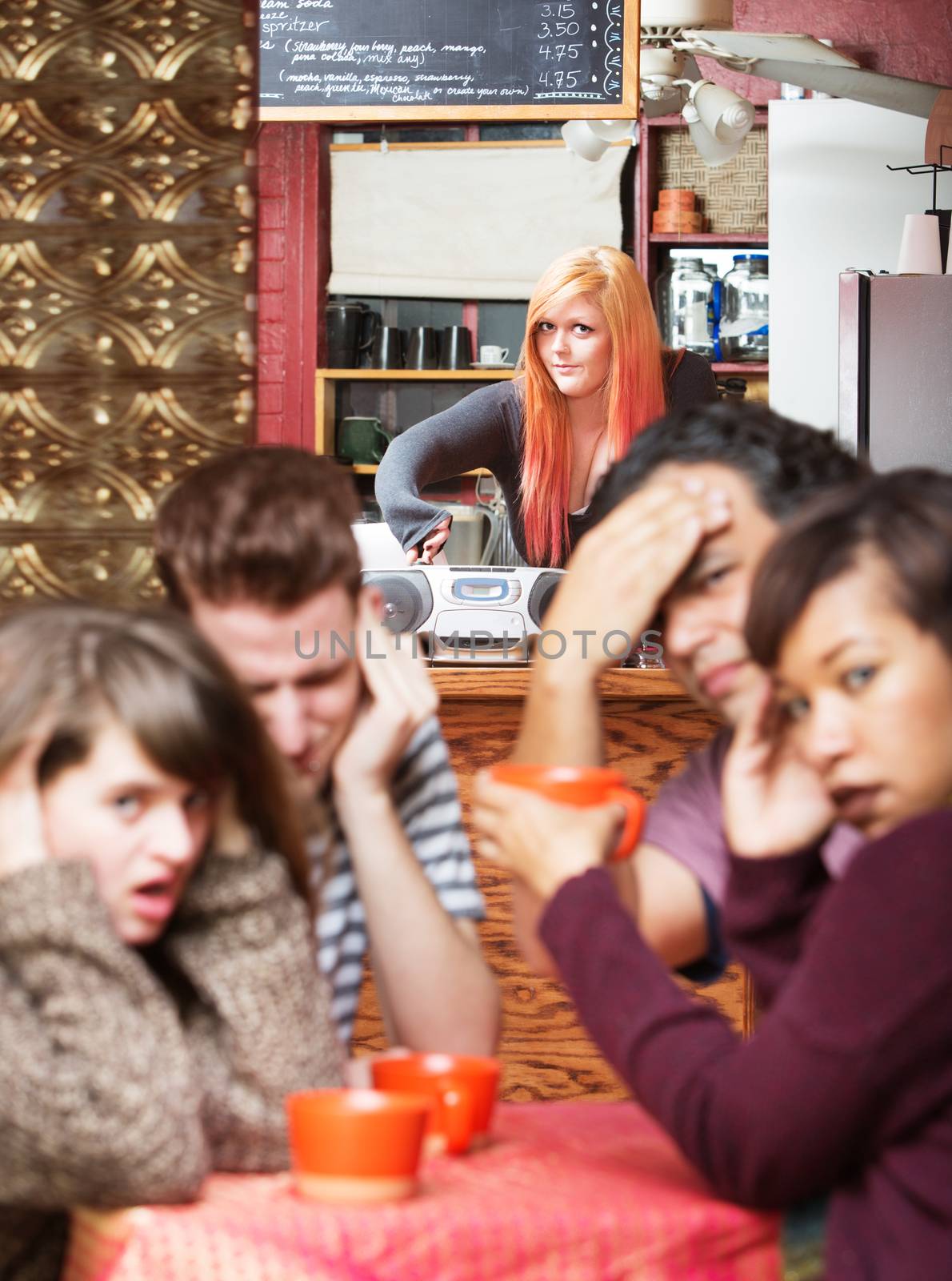 Young cafe employee trying to kick out customers with loud music