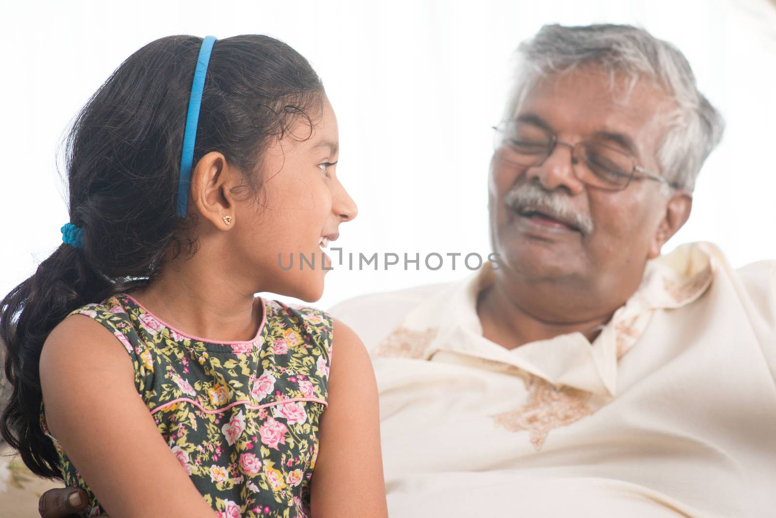 Portrait of Indian family at home. Grandparent and grandchild having conversation. Asian people living lifestyle. Grandfather and granddaughter.