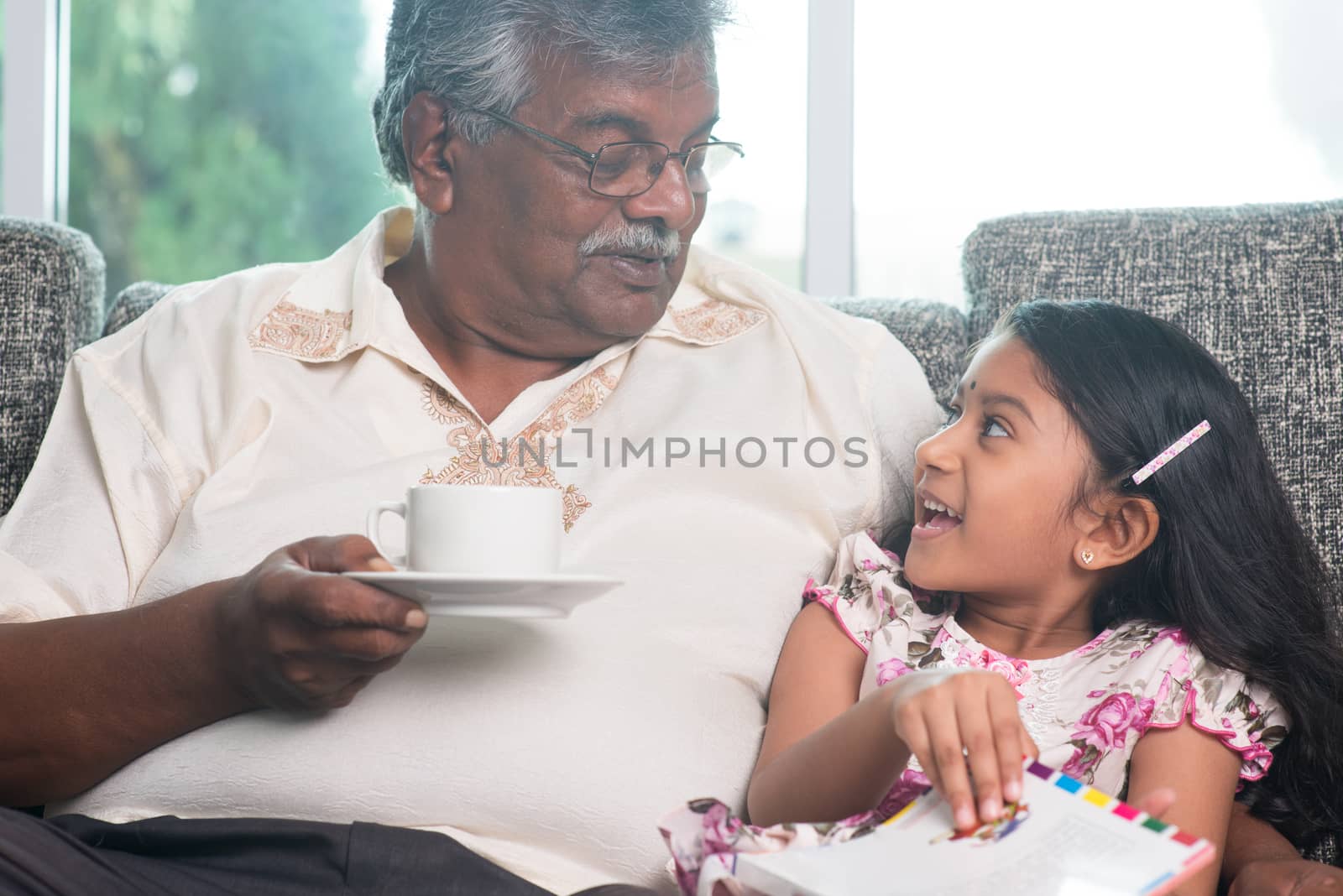 Granddaughter and grandfather reading book together by szefei
