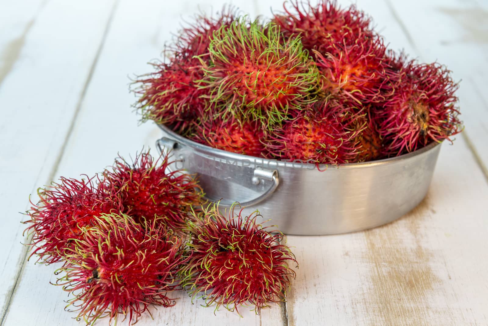 Red rambutan Nephelium lappaceum on white board. Fruit tropical tree of the family Sapindaceae , native to South - East Asia , cultivated in many countries in the region