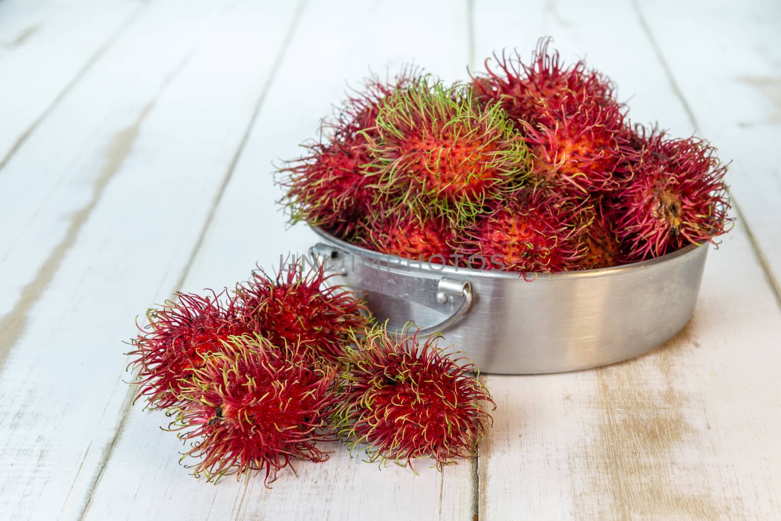 Red rambutan Nephelium lappaceum on white board. Fruit tropical tree of the family Sapindaceae , native to South - East Asia , cultivated in many countries in the region
