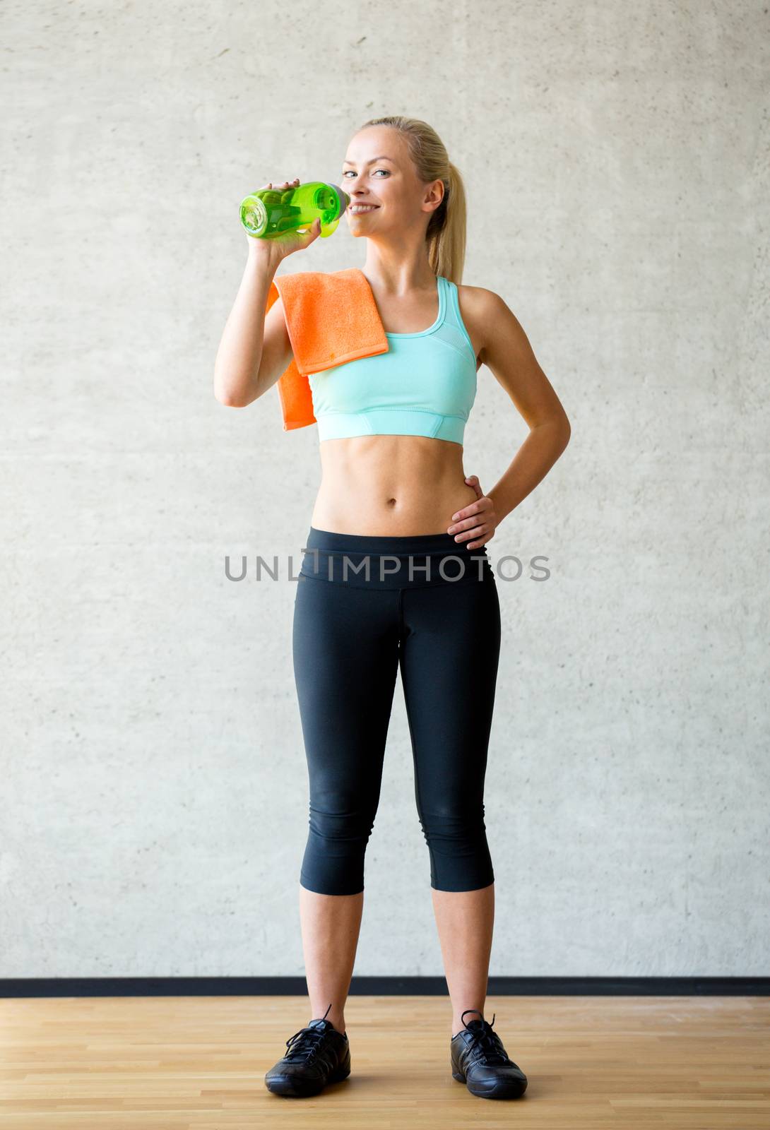 woman with bottle of water in gym by dolgachov