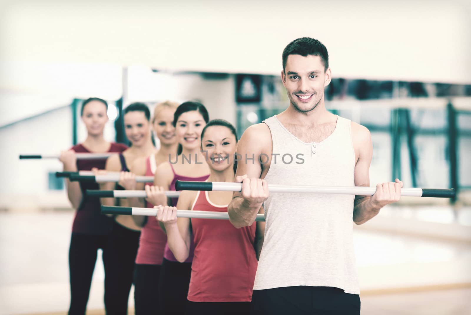 group of smiling people working out with barbells by dolgachov