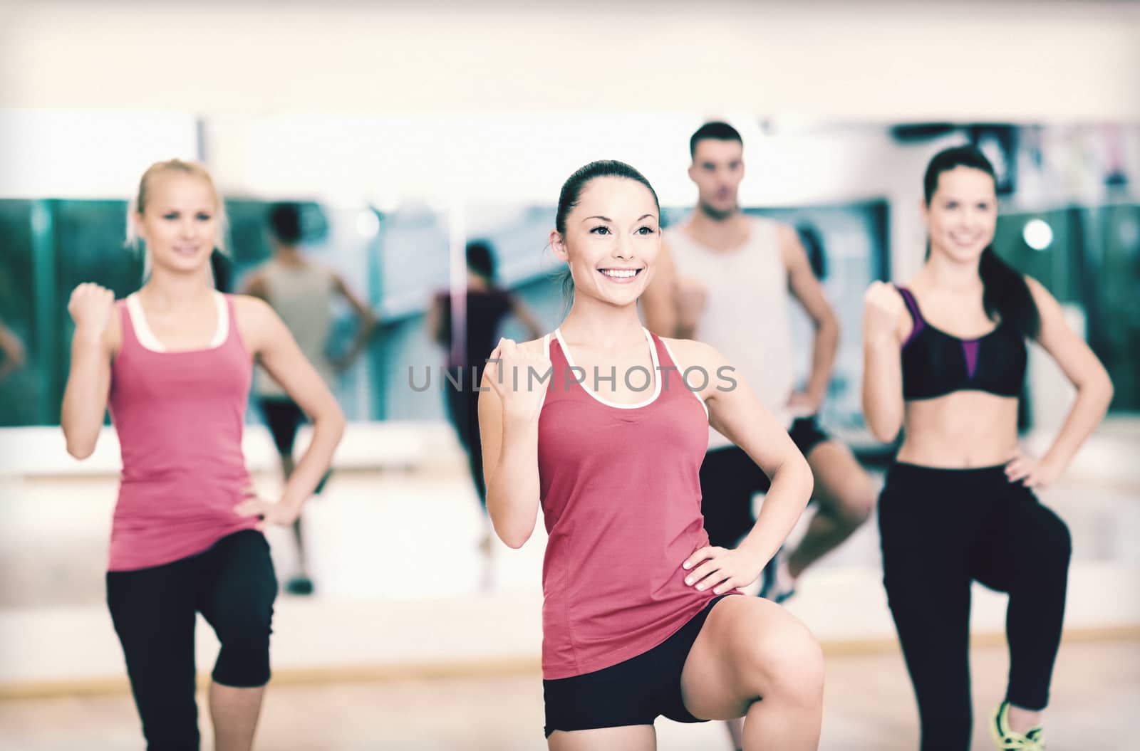 fitness, sport, training, gym and lifestyle concept - group of smiling people with trainer exercising in the gym