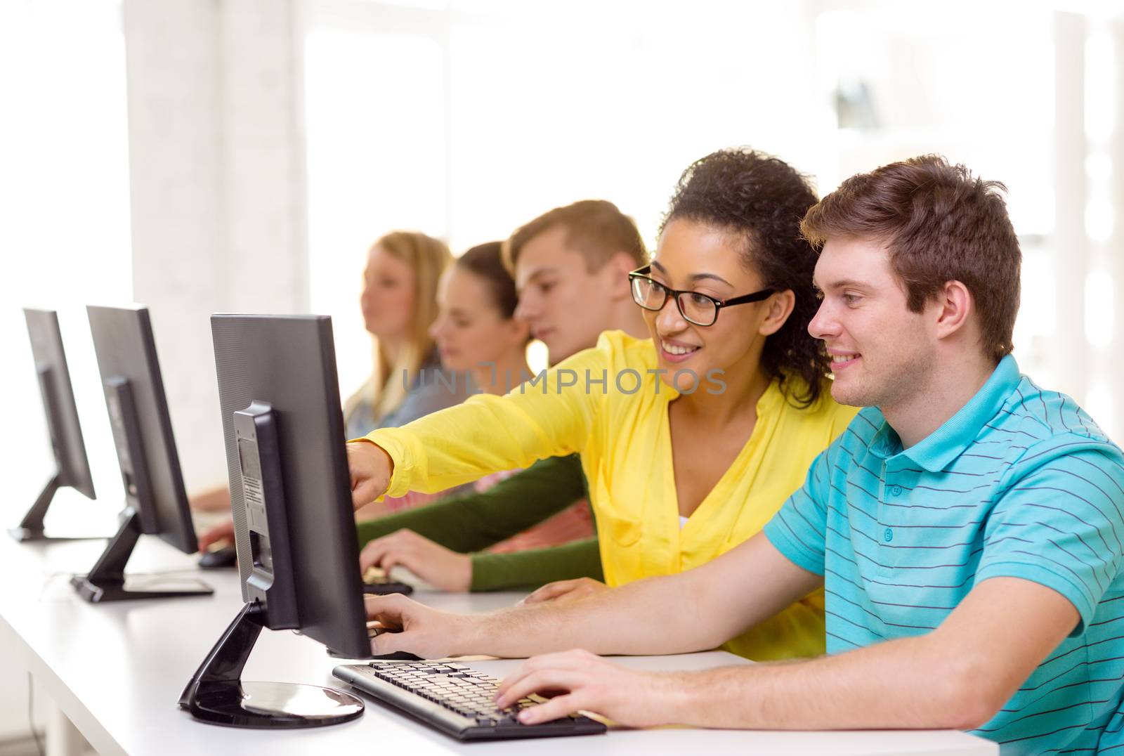 smiling students in computer class at school by dolgachov