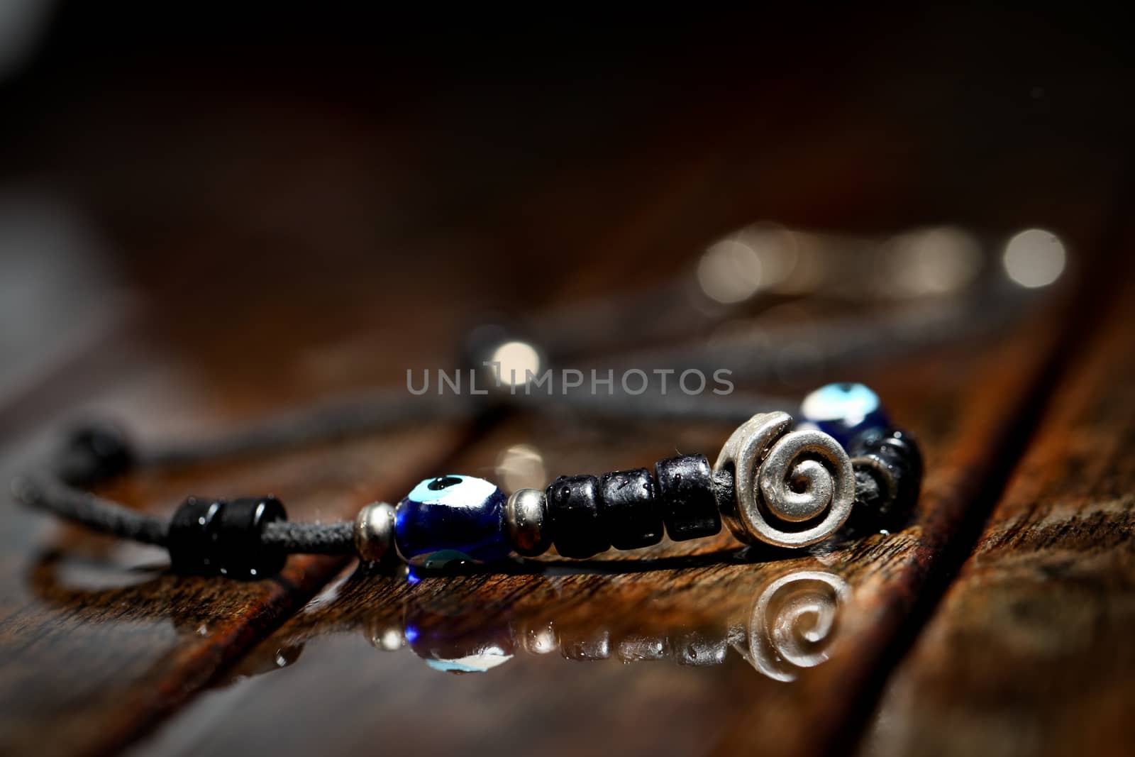 Hand made necklace on wodden wet background