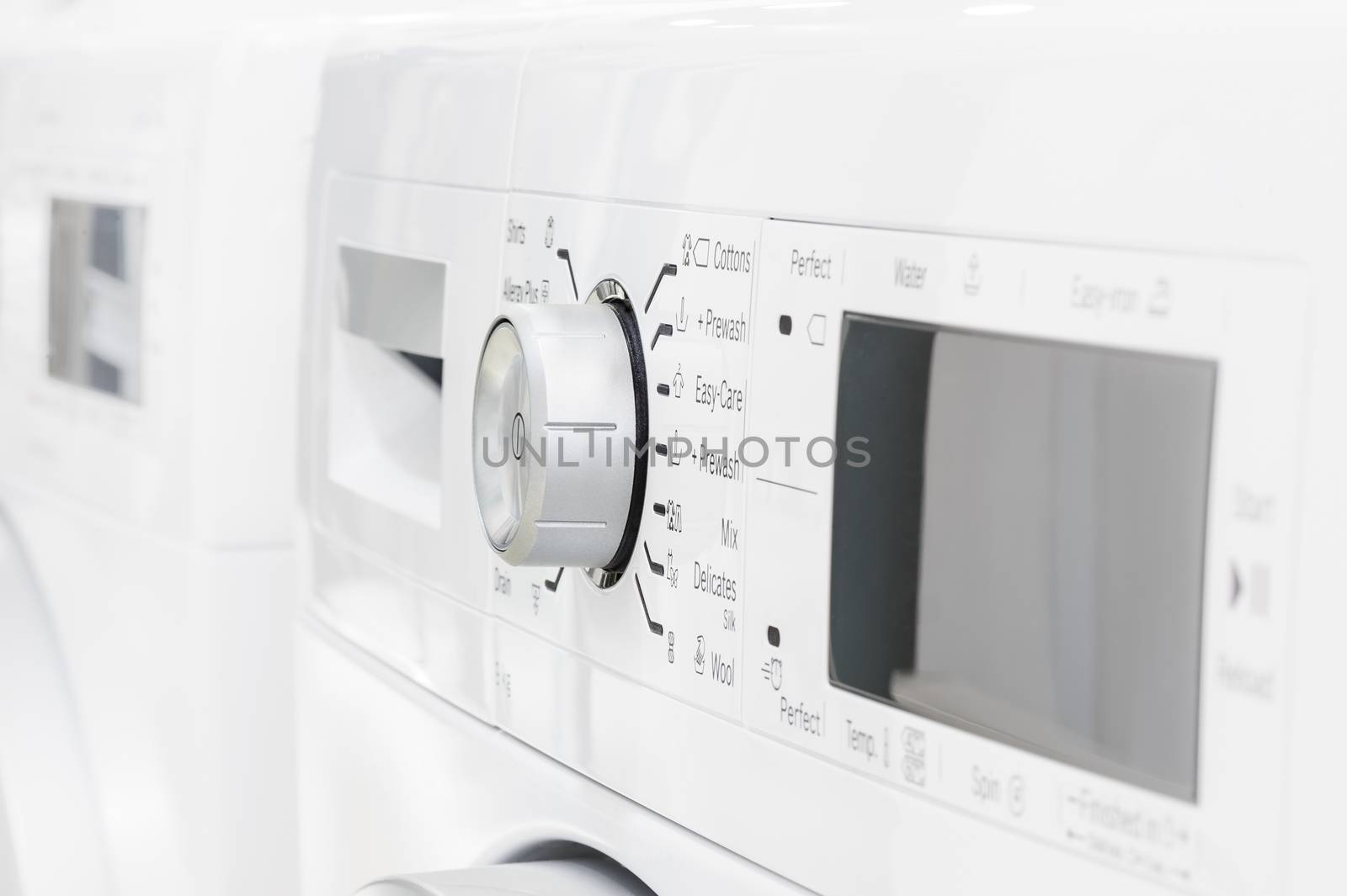 closeup of new white laundry or washing machine, selective focus on control elements