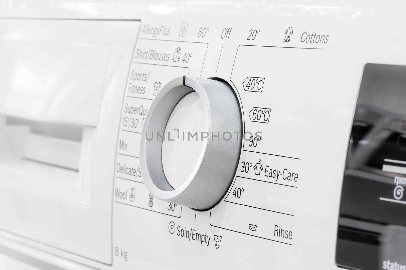 closeup of new white laundry or washing machine, selective focus on control elements