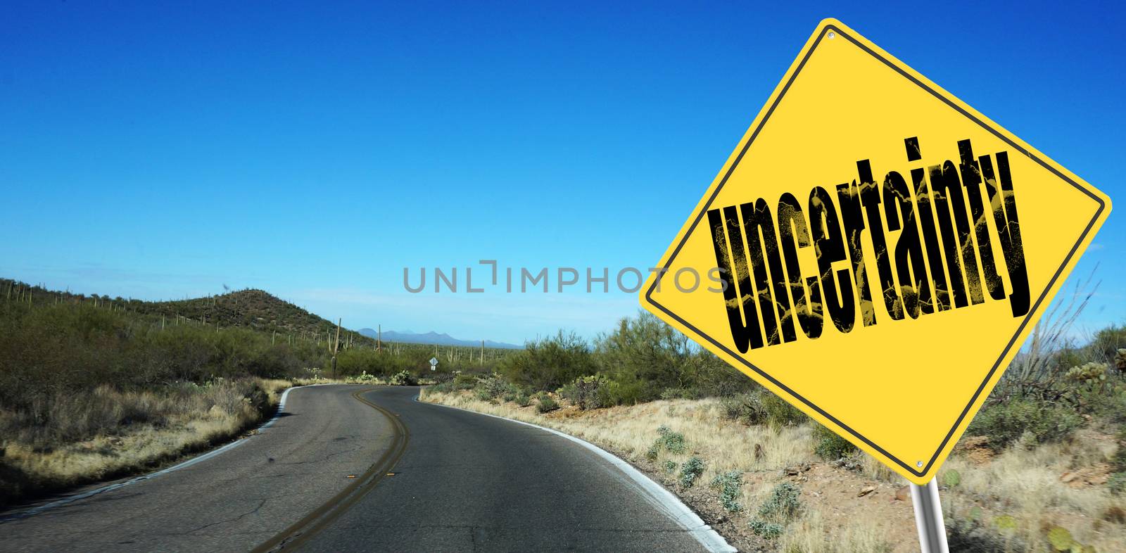 Uncertainty ahead sign on a sky background and dessert road