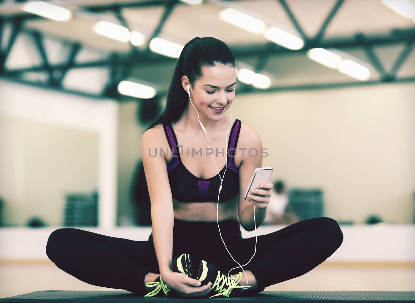 fitness, sport, training, gym, technology and lifestyle concept - smiling woman with smartphone