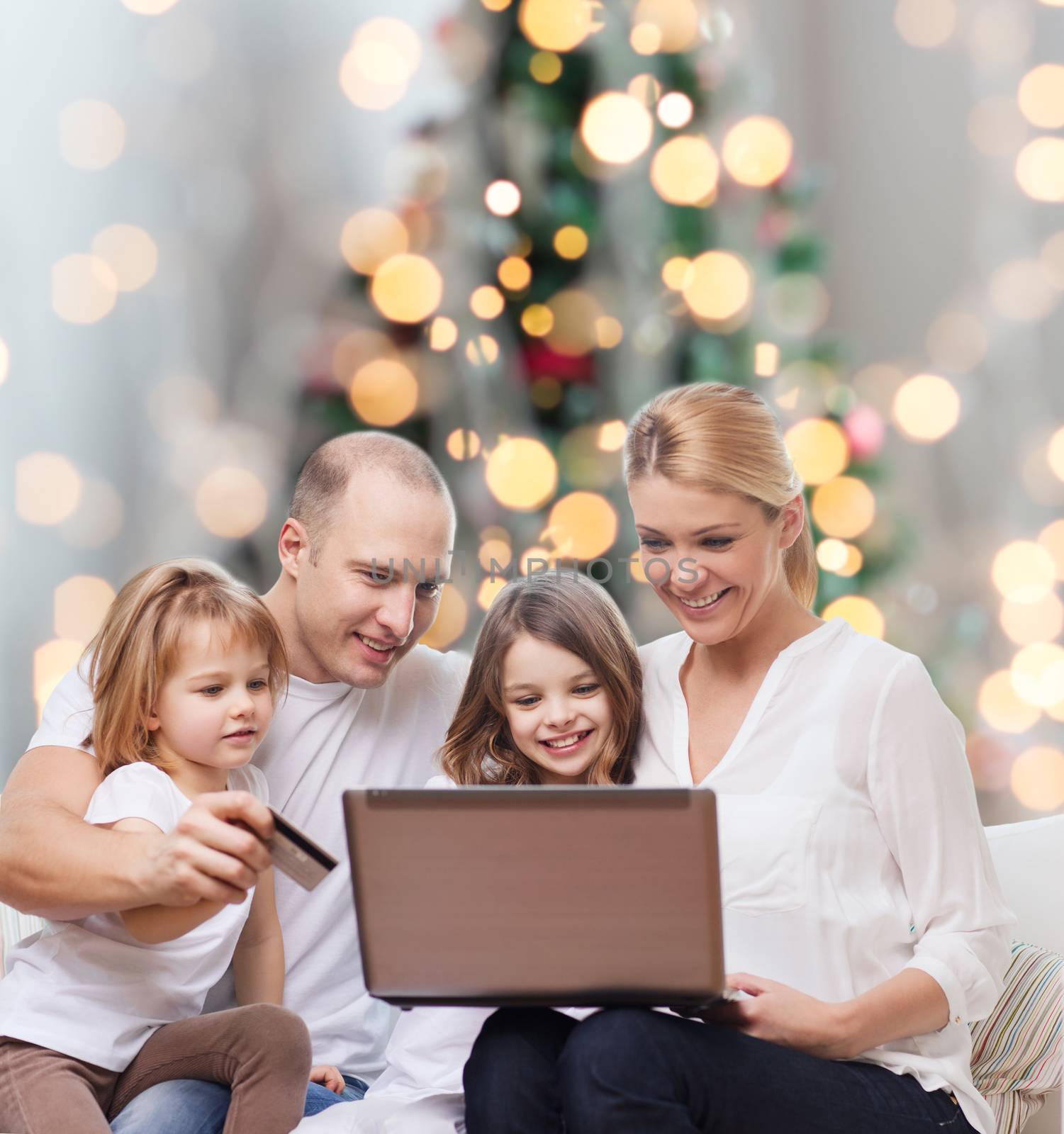 happy family with laptop computer and credit card by dolgachov