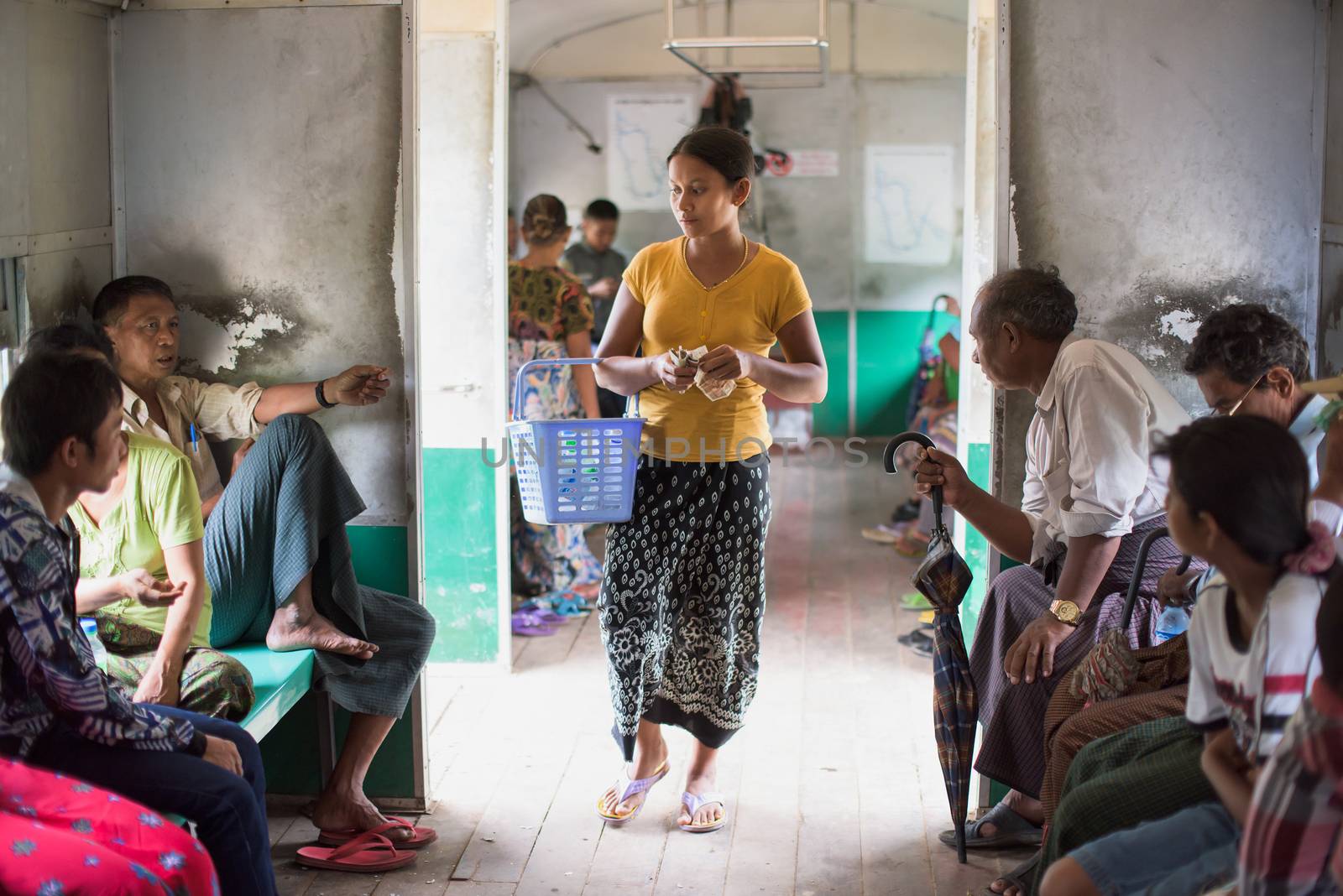 Yangon, Myanmar - July 5, 2015: Woman selling food and drinks onboard a commuter train at the outskirts of Yangon.