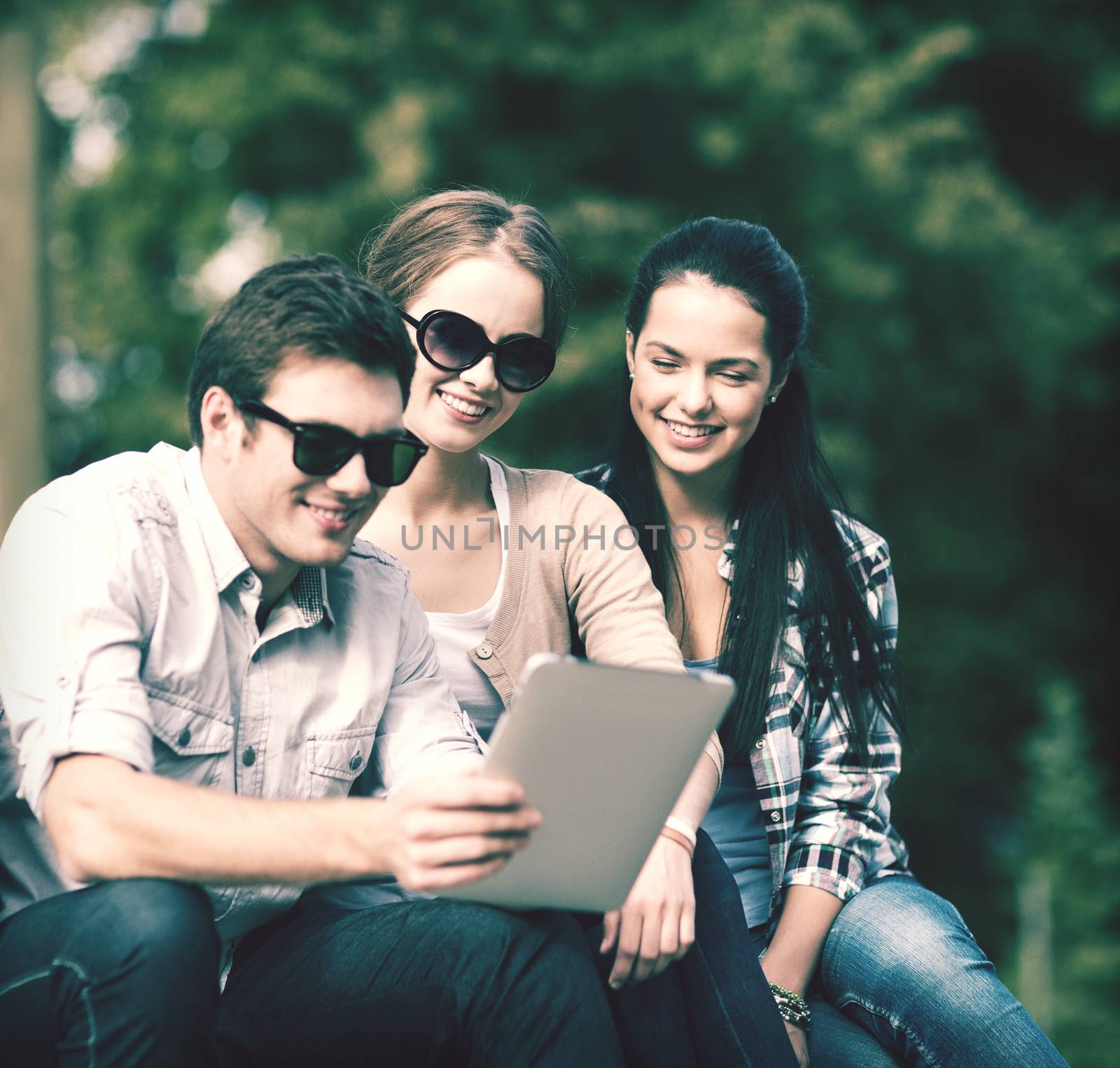 summer, internet, education, campus and teenage concept - group of students or teenagers with laptop and tablet computers hanging out