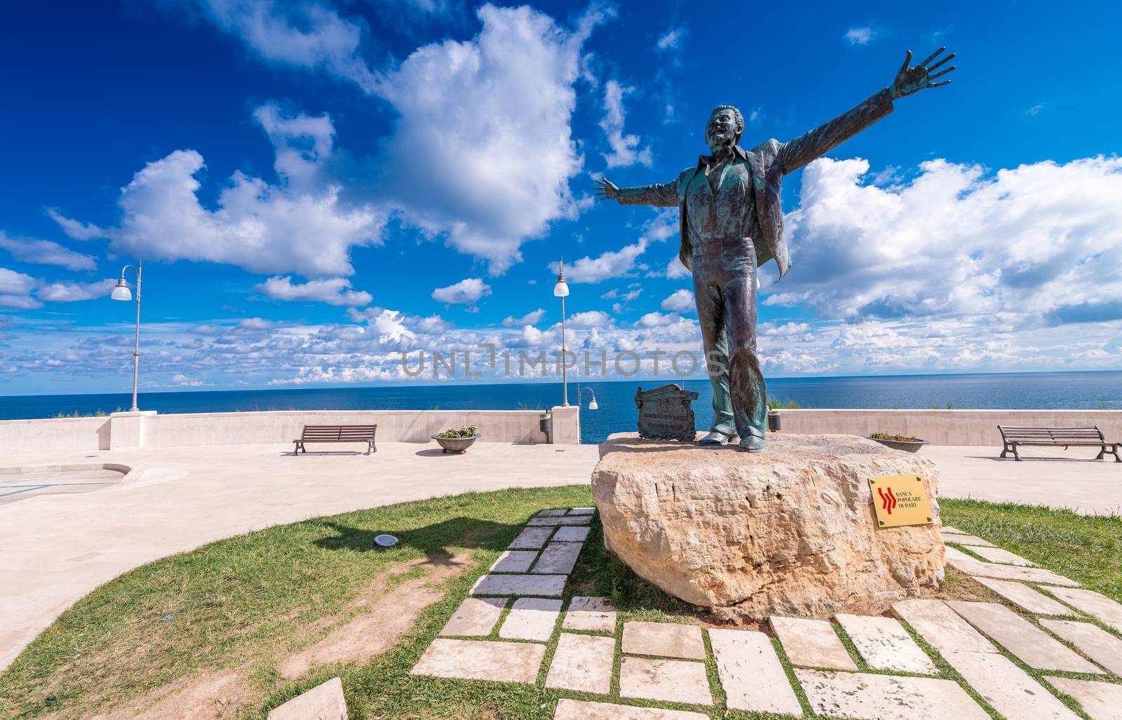 POLIGNANO A MARE, ITALY SEPTEMBER 1, 2014: Domenico Modugno Statue with clouds background in Polignano a Mare.