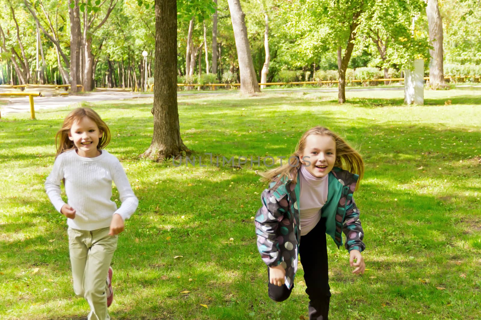 Photo of two running girls in summer