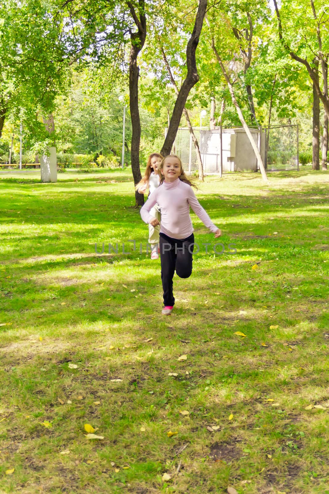 Photo of two running girls in summer