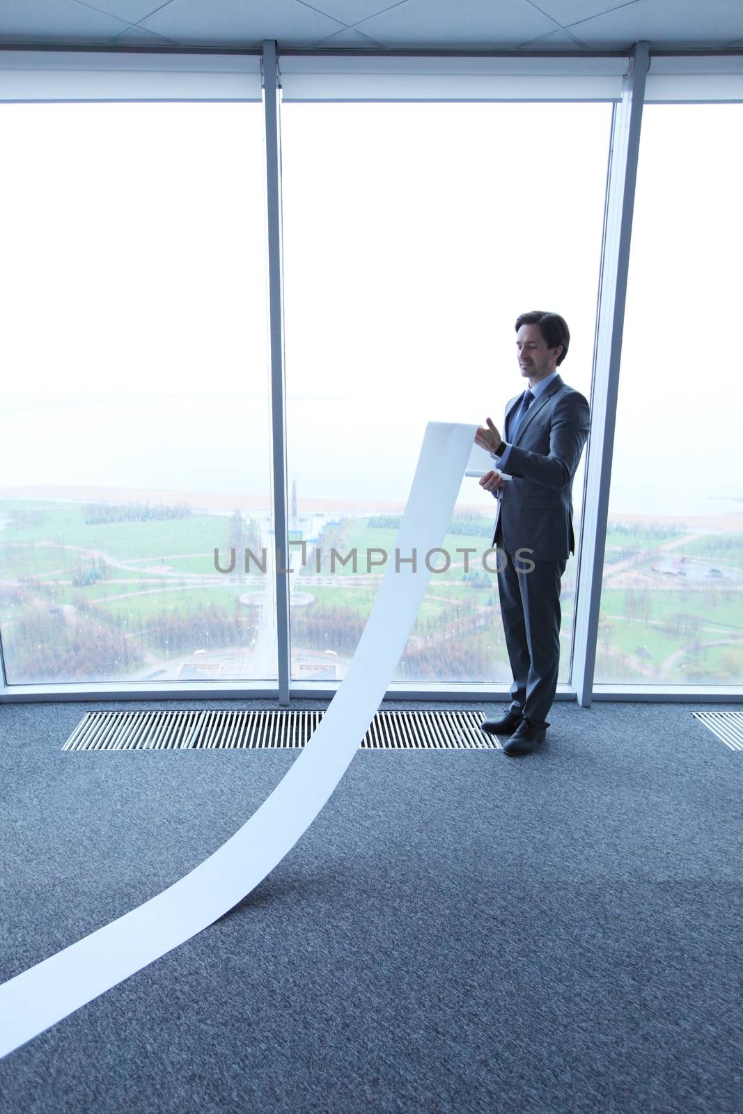 Office worker unrolling long sheet of paper