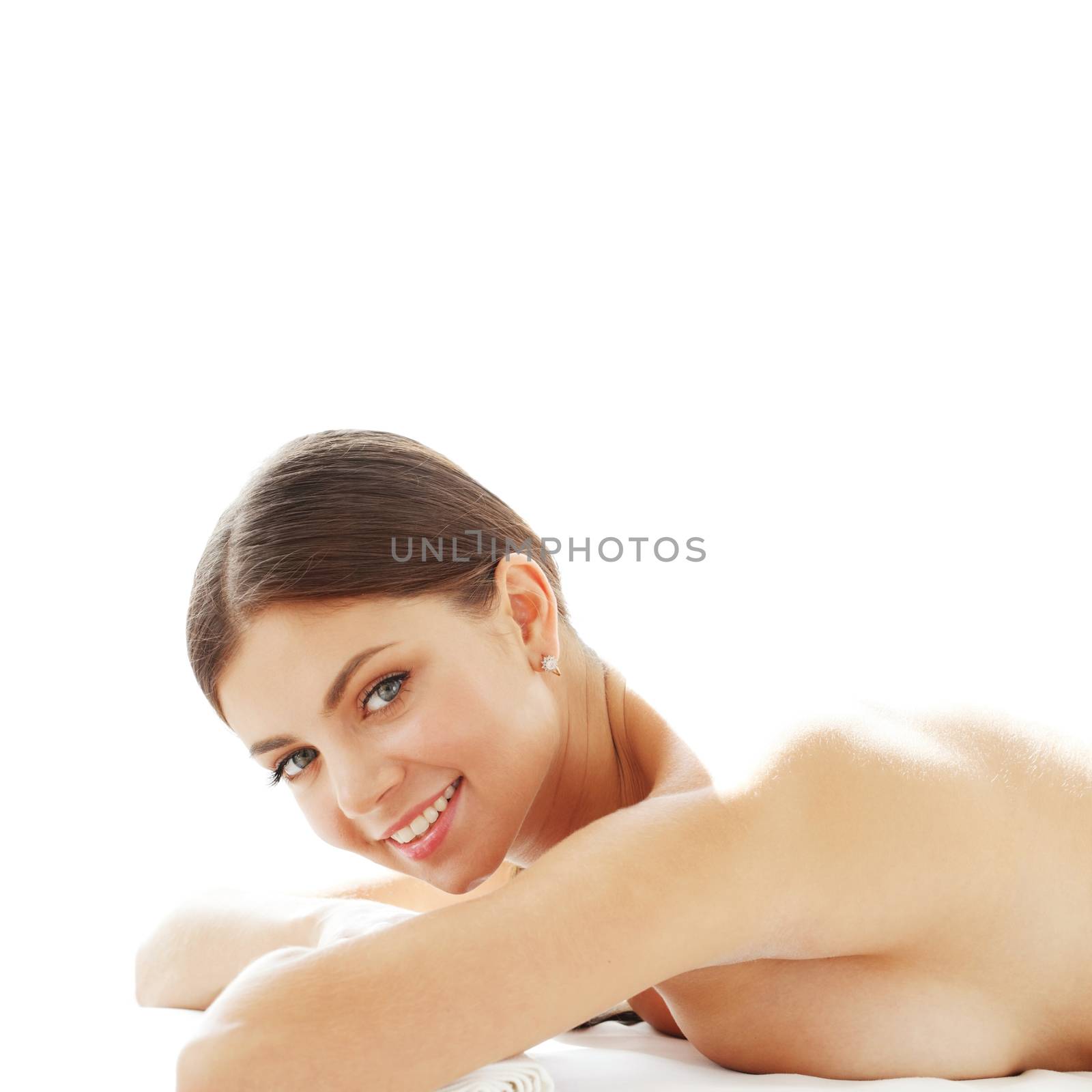 Happy beautiful young woman on massage table isolated on white