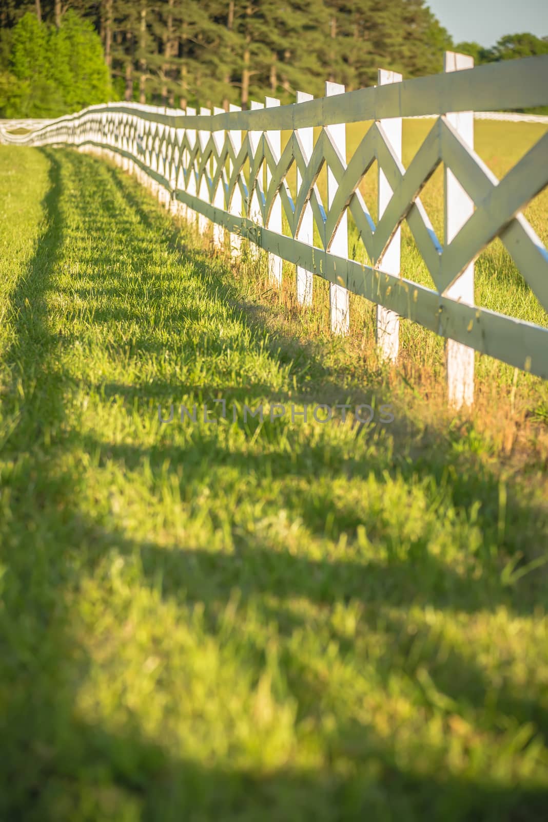  white fence leading up to a big red barn by digidreamgrafix