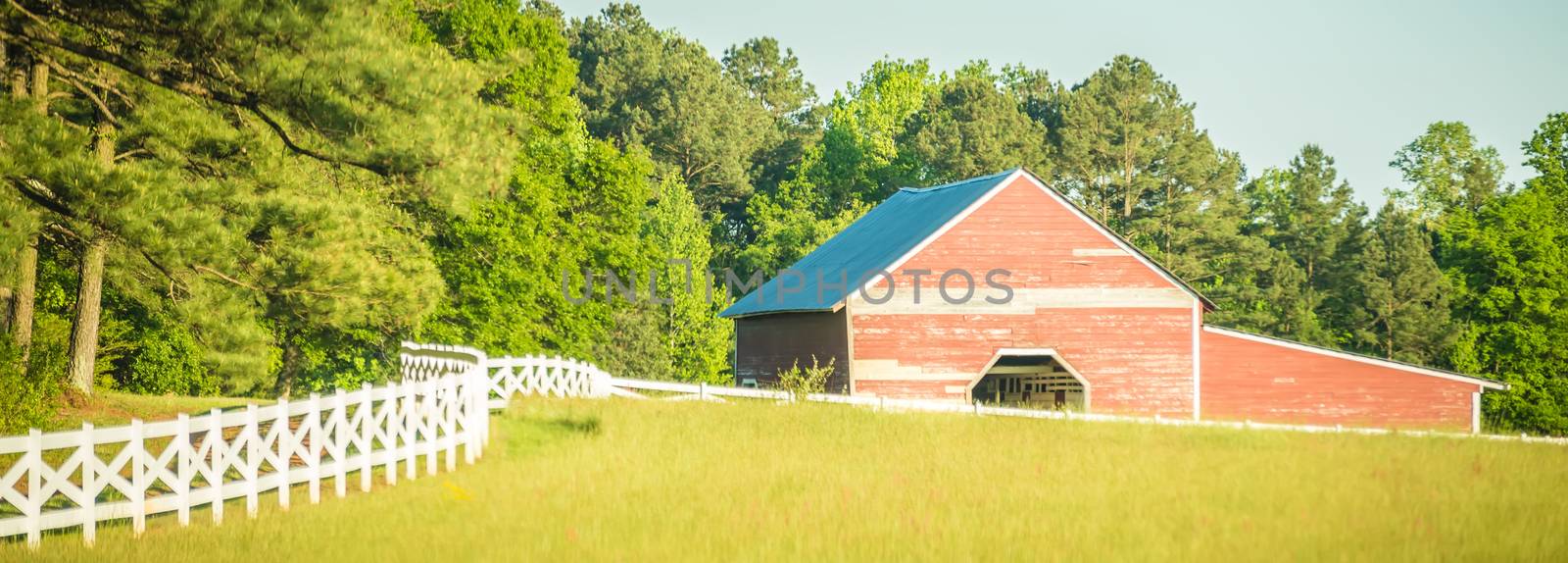  white fence leading up to a big red barn by digidreamgrafix