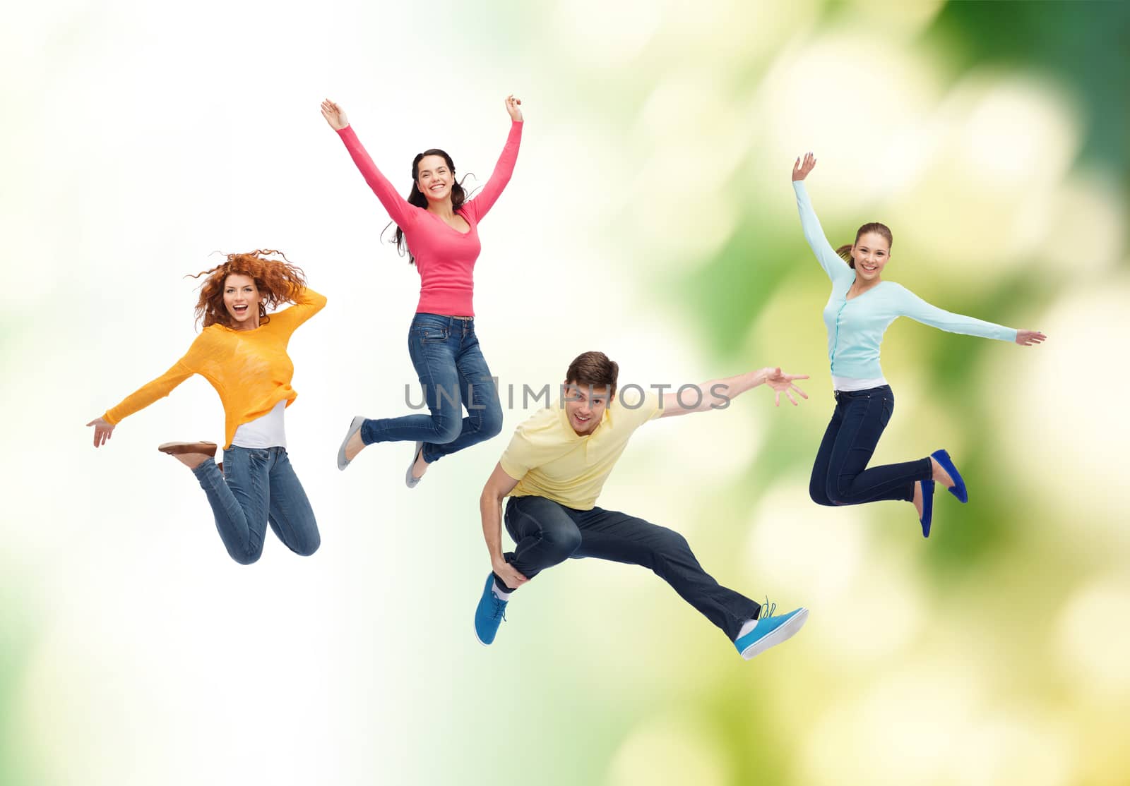 group of smiling teenagers jumping in air by dolgachov