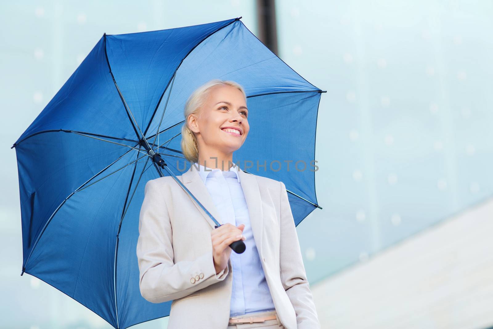 young smiling businesswoman with umbrella outdoors by dolgachov