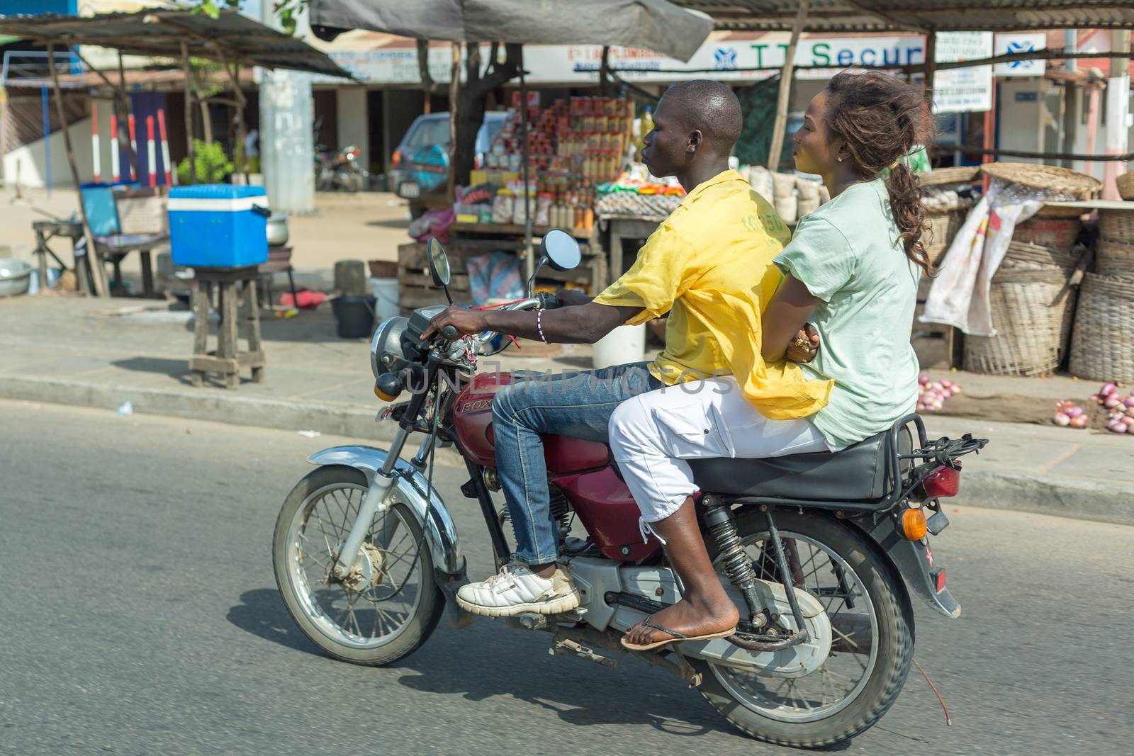 Cotonou, Benin: May 26: A woman rides a hired Motorcycle taxi, the most common means of hired transportation in the city, on May 26, 2015 in Cotonou, Benin.