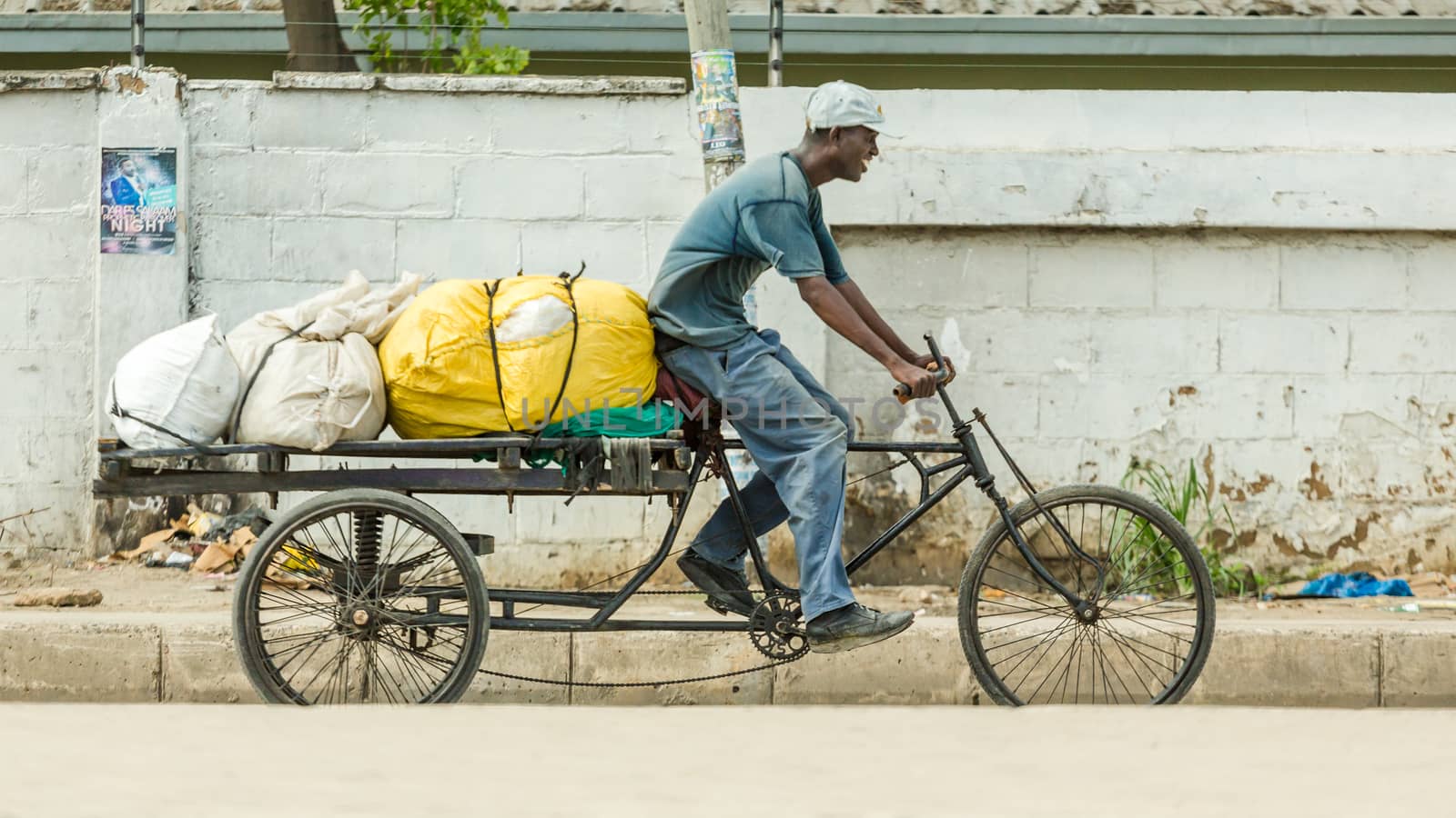 Dar Es Salaam: April 22: A man rides his customised bicycle fitted with a trailer that is loaded with large sacs, on April 22, 2015 in Dar Es Salaam, Tanzania