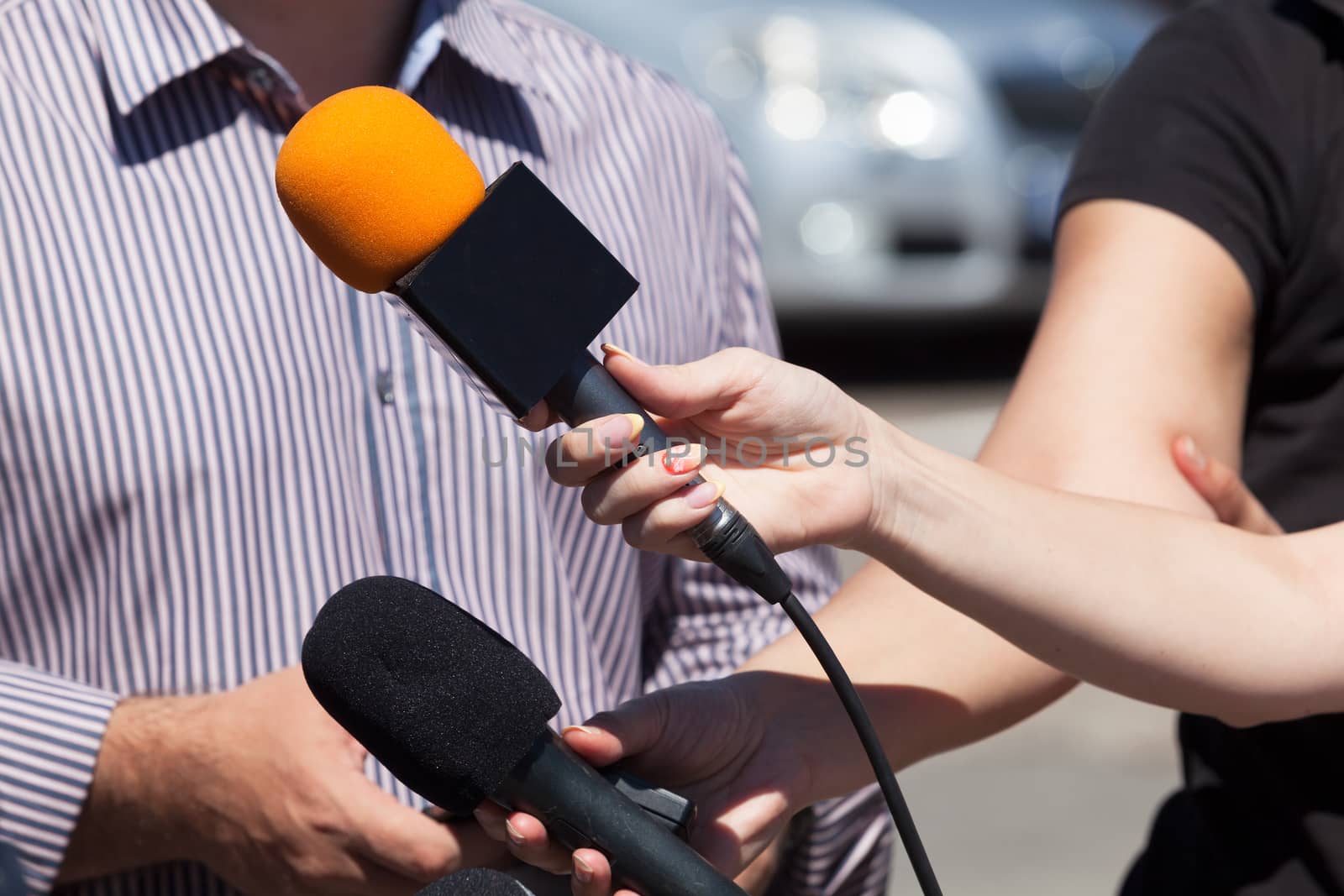 Reporters taking interview at press conference.