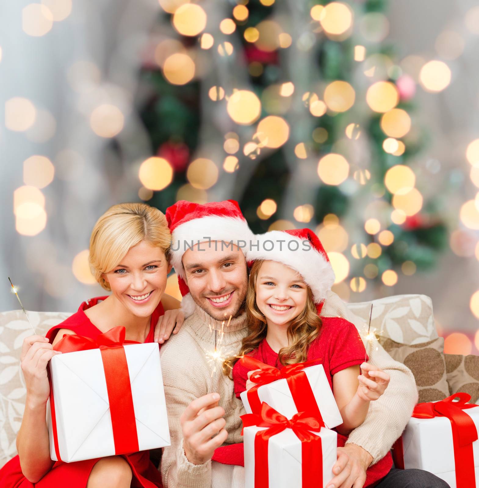 happy family in santa helper hats with gift boxes by dolgachov