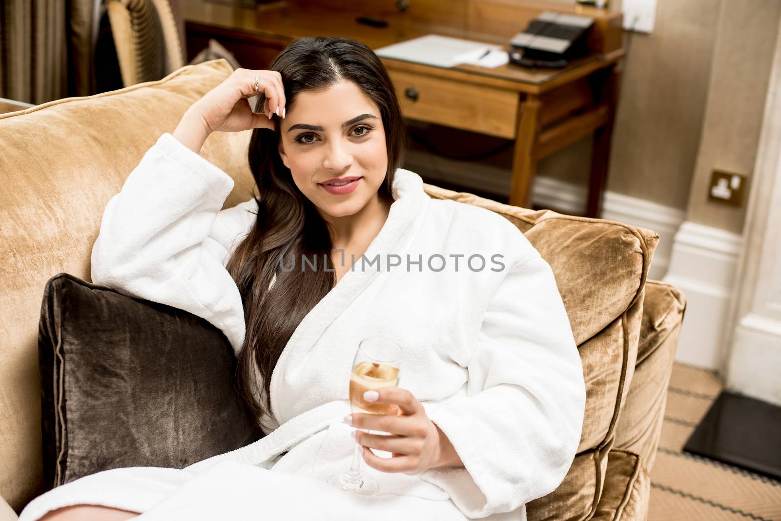 Relaxed woman laying in sofa with glass of champagne