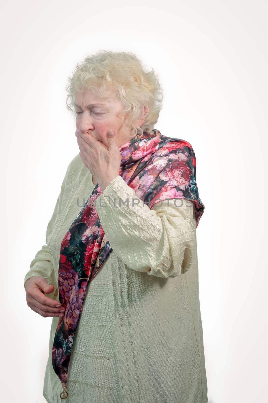 Portrait of an elderly woman coughs on a white background.