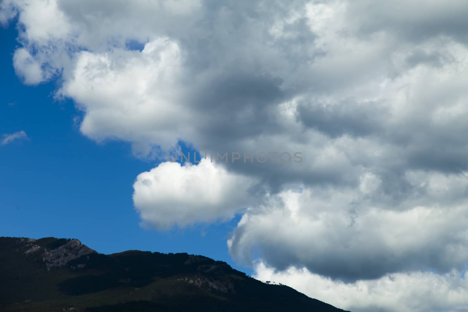 Clouds over mountains majestically float towards the sea