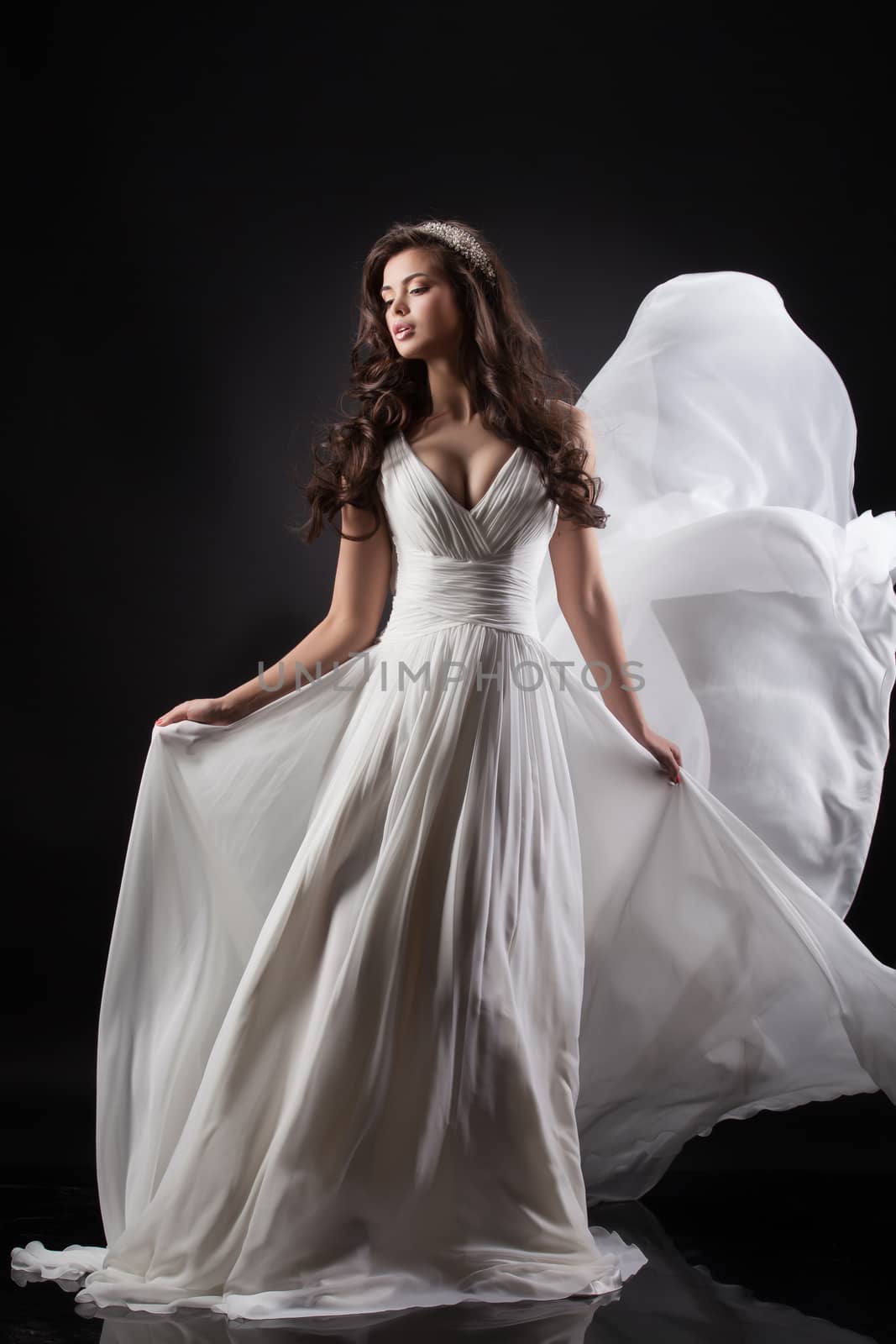 Young beautiful woman in a wedding dress on a black background