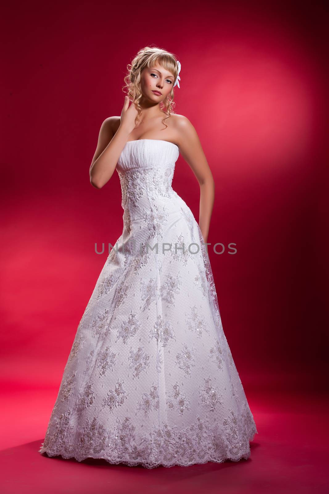 Young woman in a wedding dress on a studio background