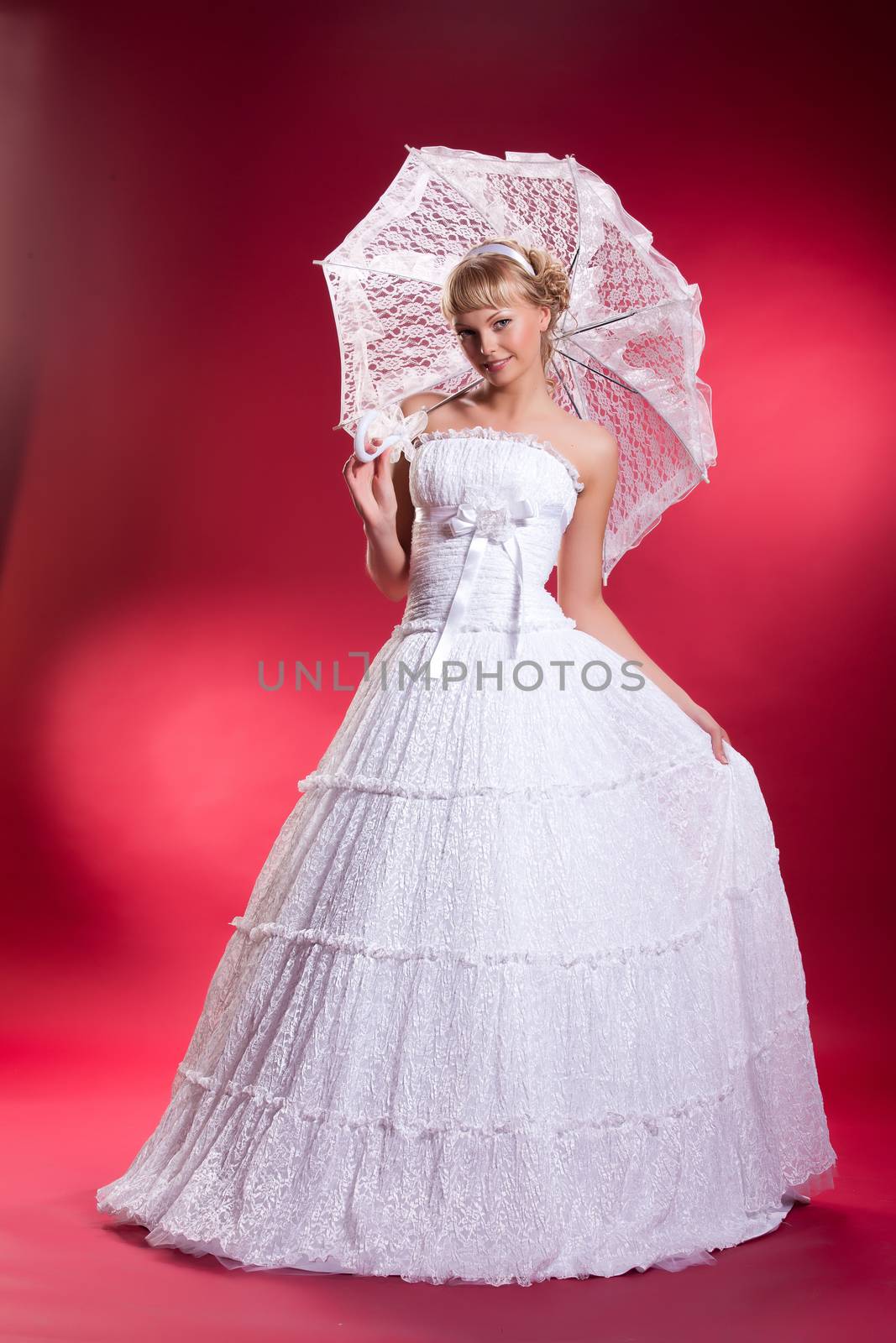 Young woman in a wedding dress on a studio background