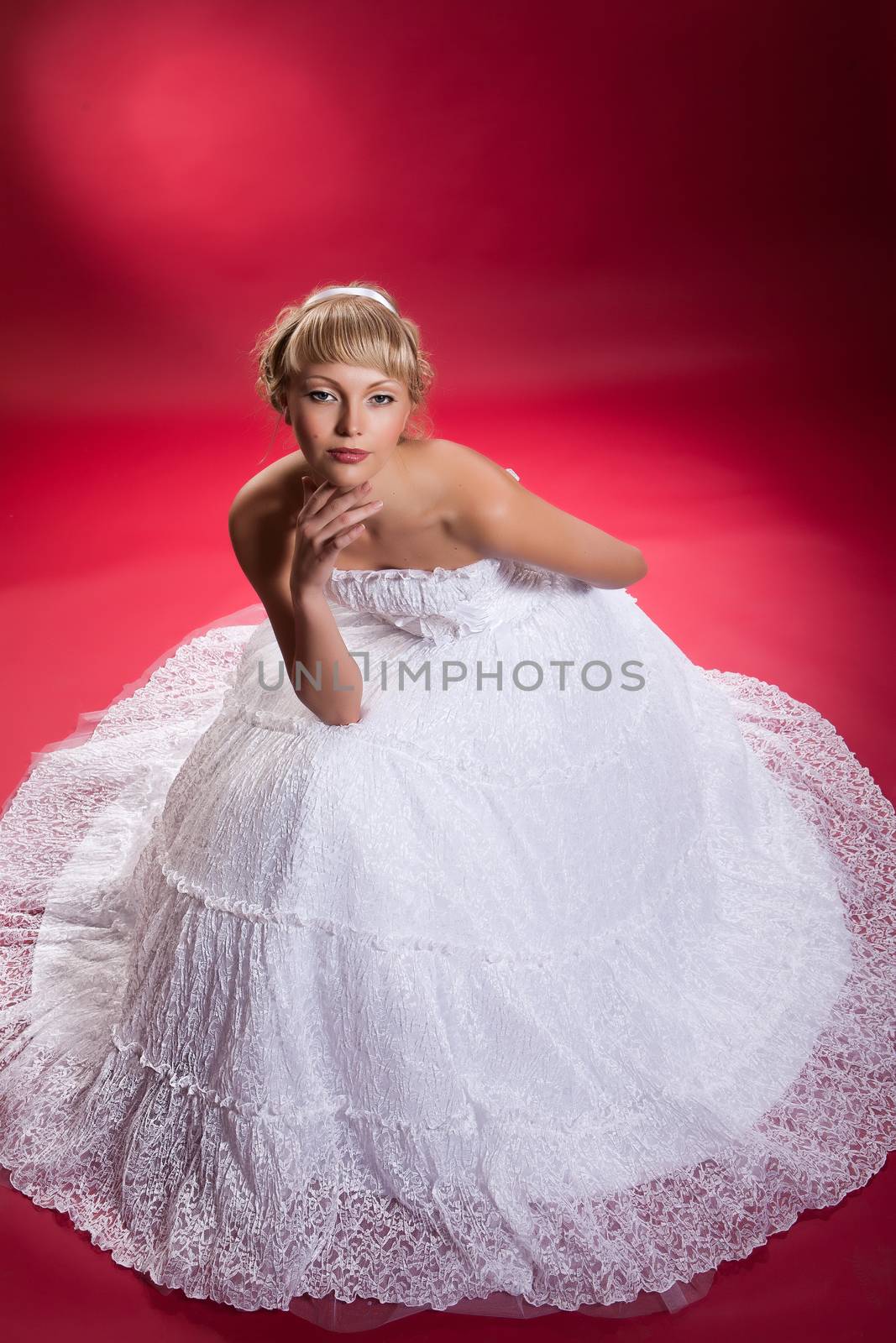 Young woman in a wedding dress on a studio background