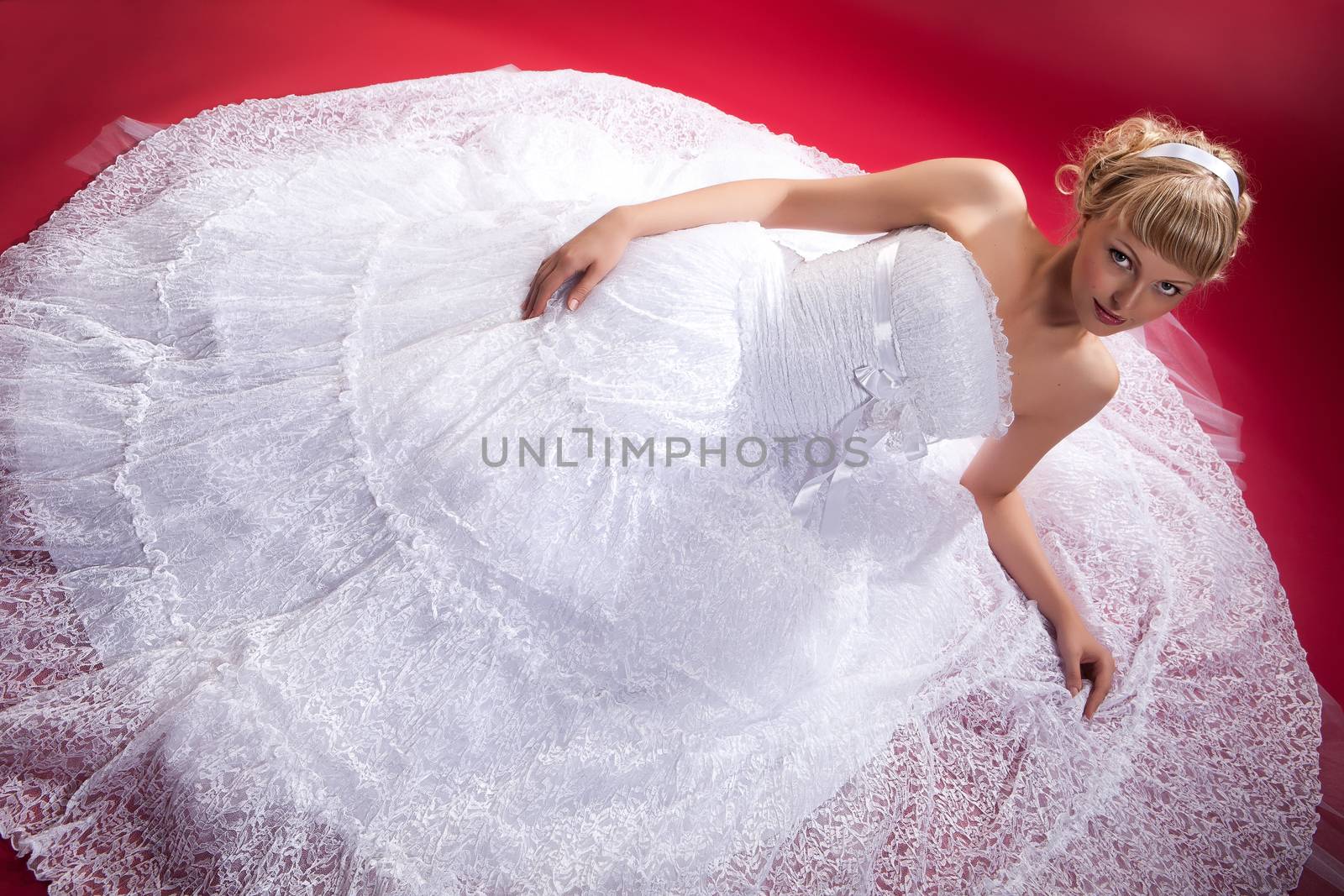 Young woman in a wedding dress on a studio background