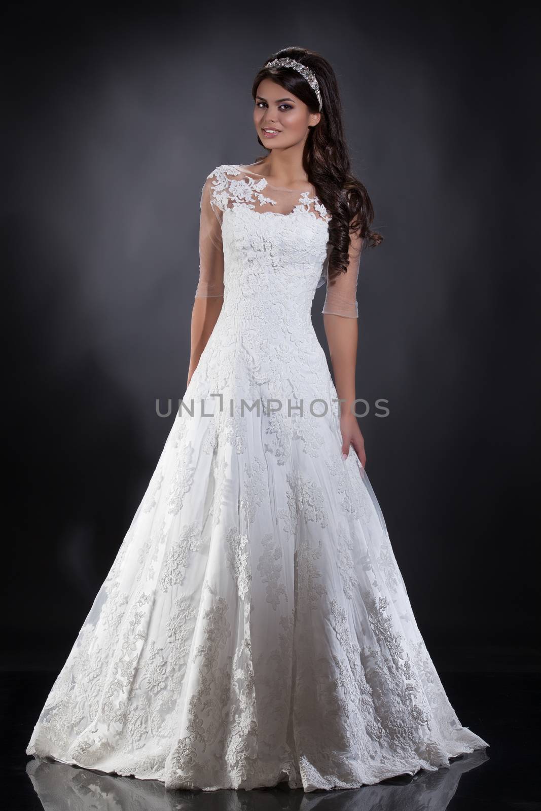 Young beautiful woman in a wedding dress on a studio background