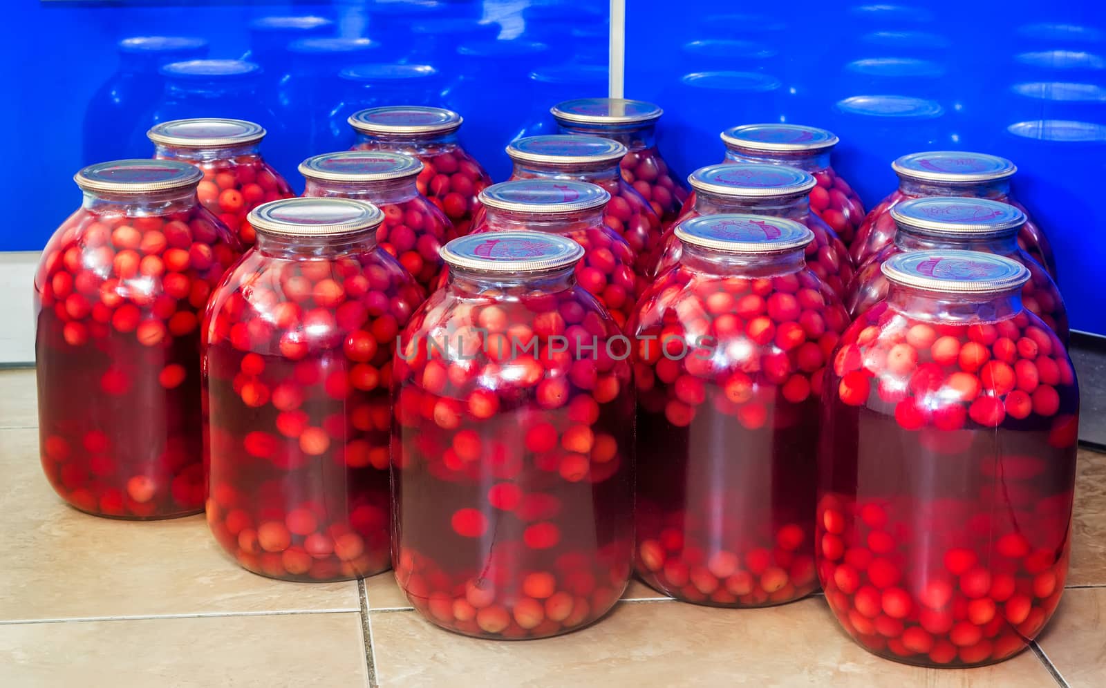 Home canning: large glass cylinders with cherry compote. by georgina198