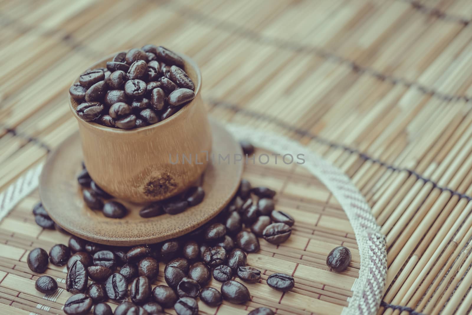 Coffee beans and coffee cup set on bamboo wooden background.Photo in retro color image style, Soft focus.