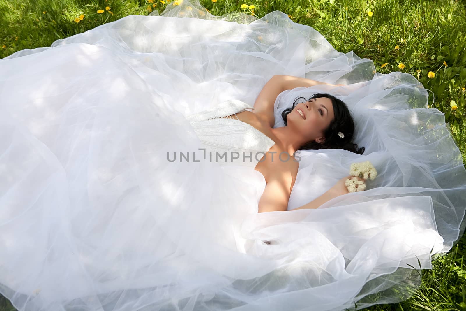 Young dark-haired beautiful woman in a wedding dress in diferent outdoor situations