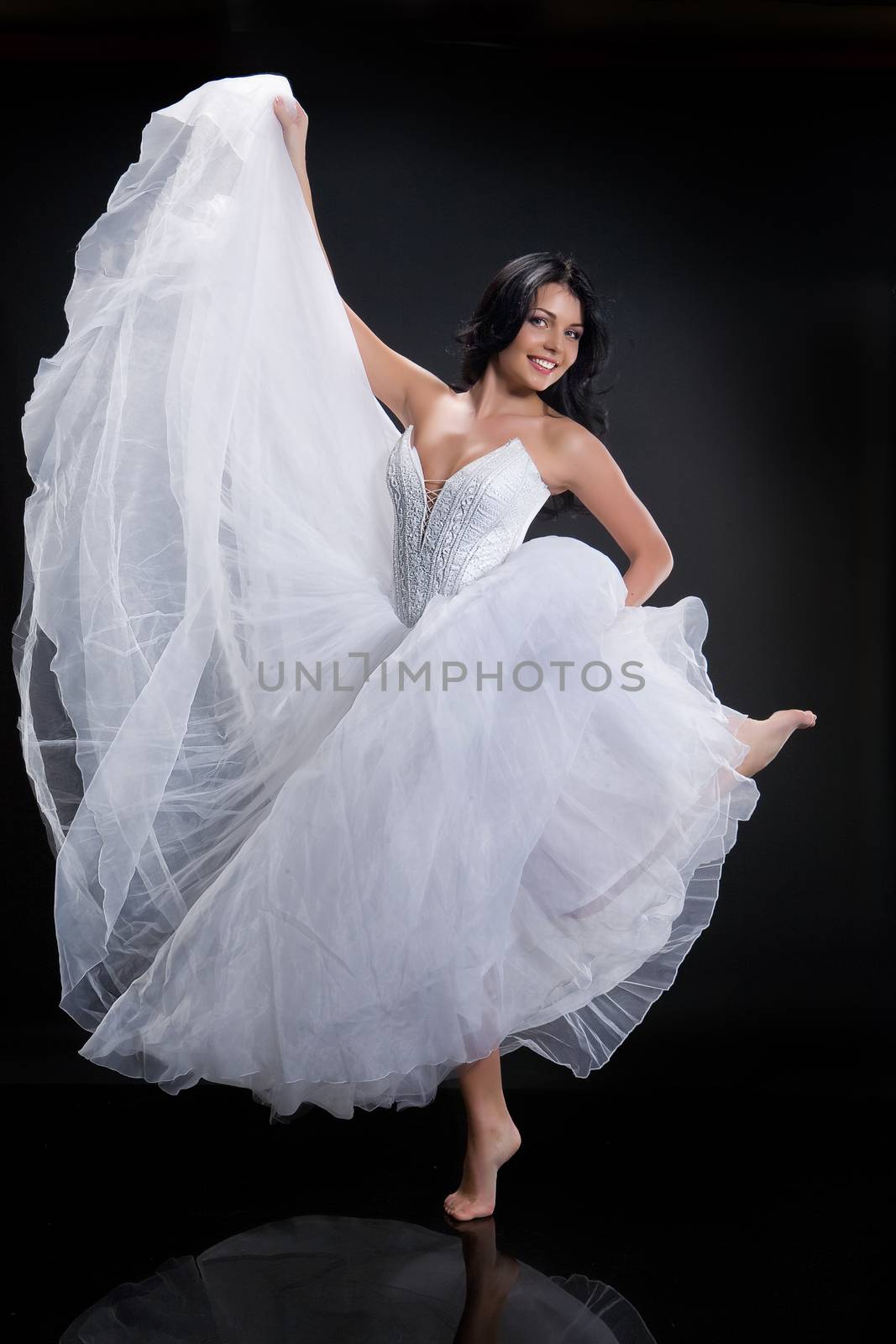 Young beautiful woman in a wedding dress on a studio background