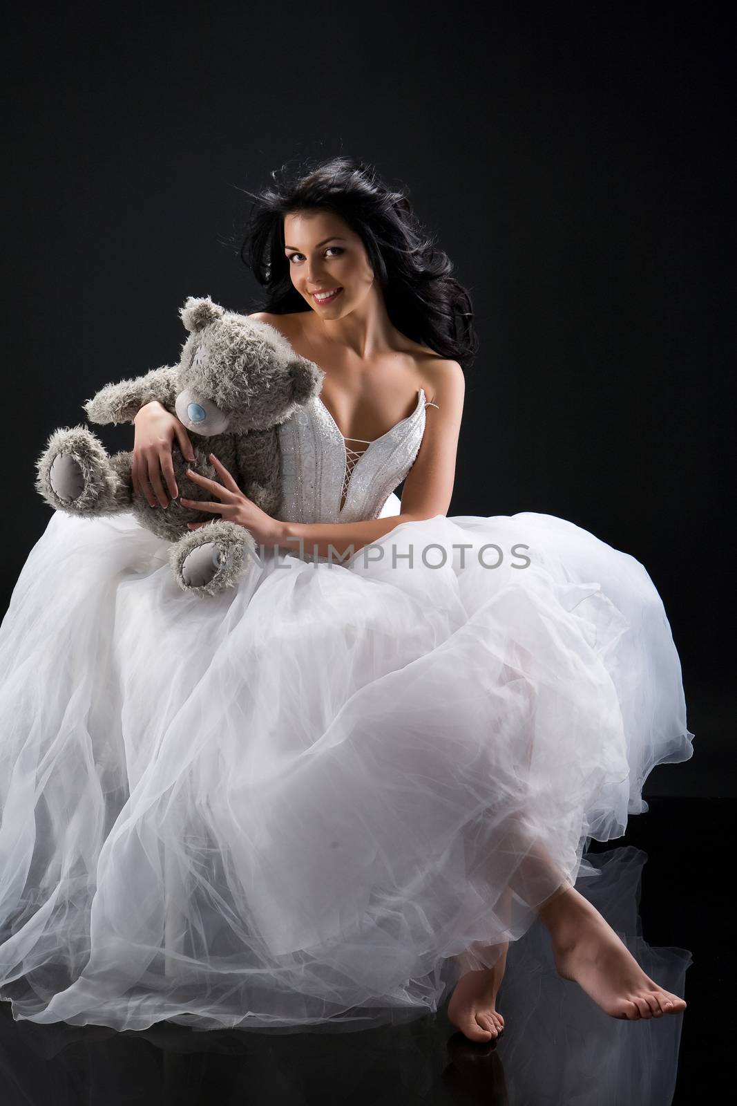 Young beautiful woman in a wedding dress on a studio background