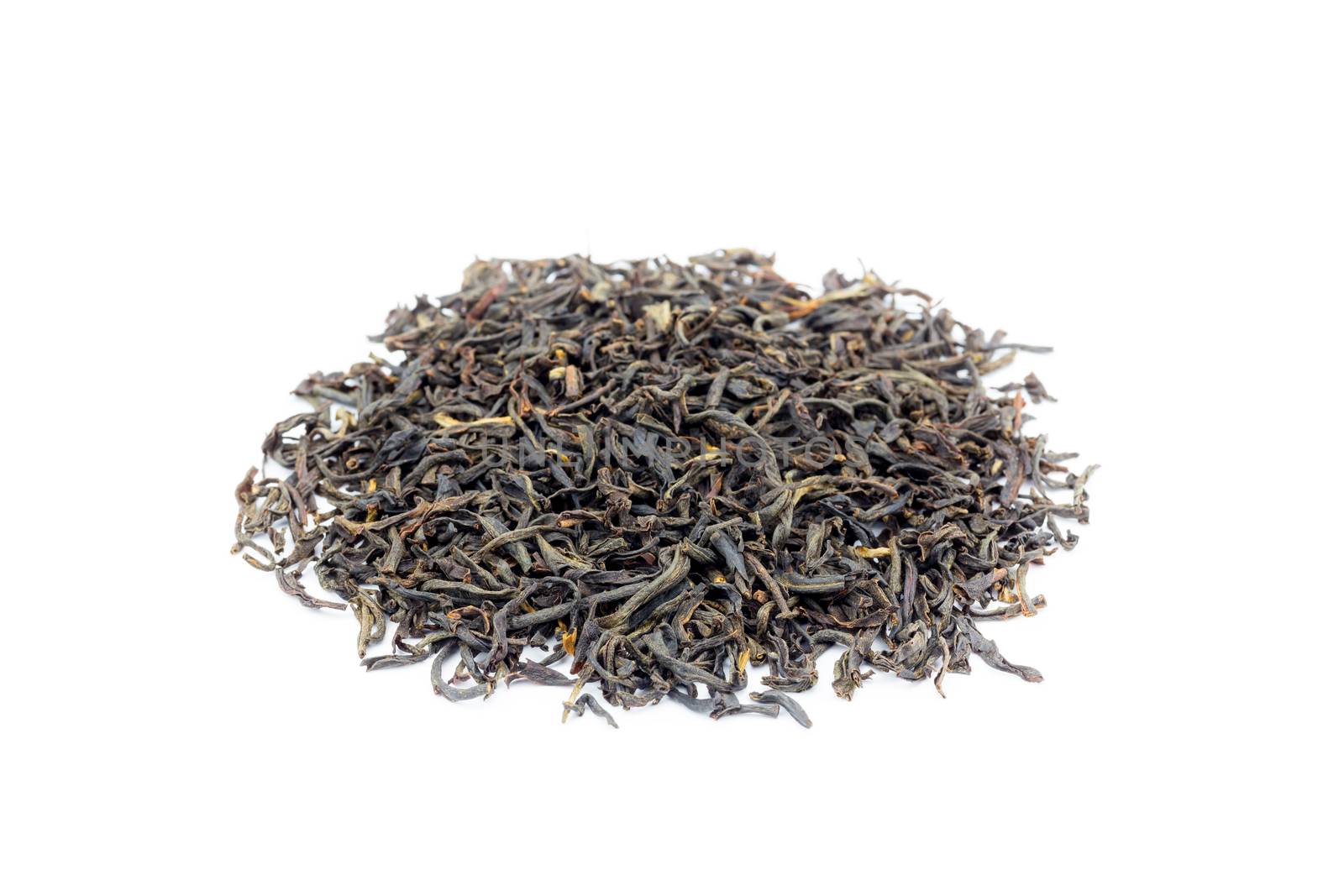 Heap of loose black tea Assam isolated on white background