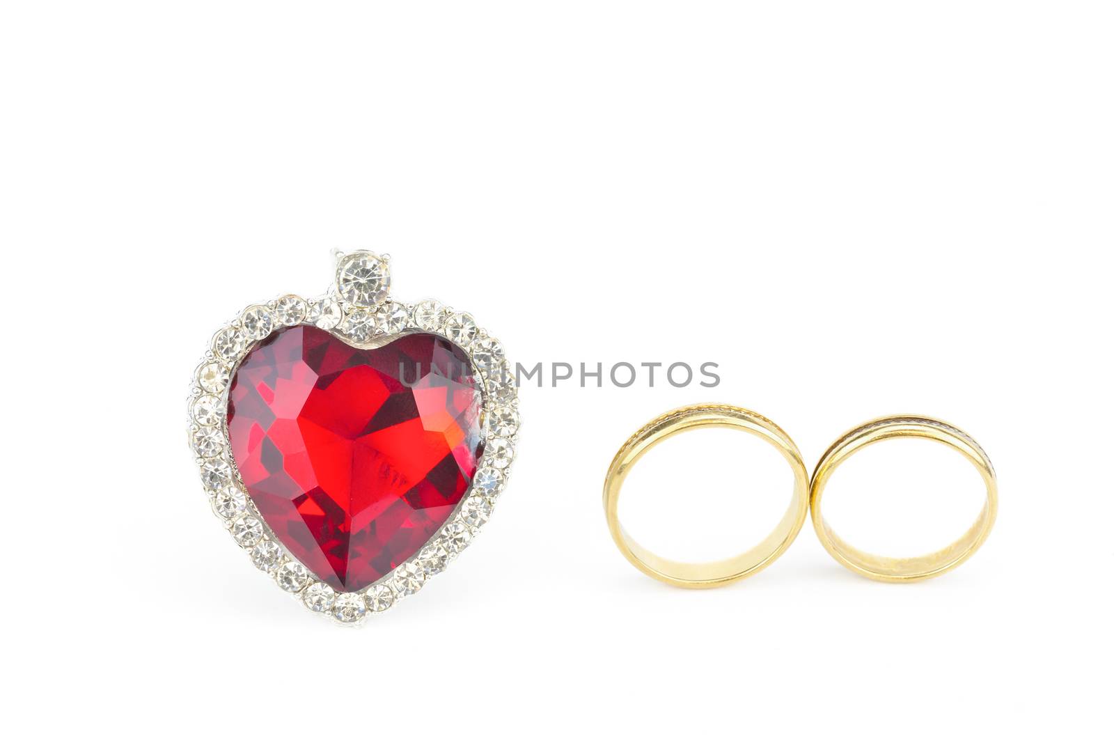 Red jewelry heart and two golden rings of man and woman isolated on white background